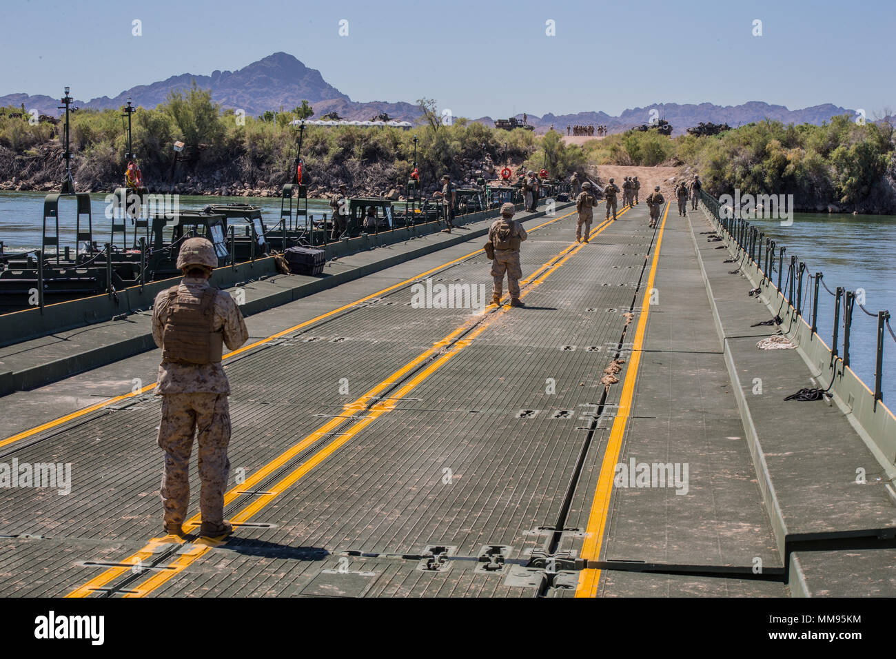 Us-Marines mit Brücke, 7 Techniker, 1. Marine Logistics Group, bereiten Sie taktische Fahrzeuge über den Colorado River während der Übung tief Strike II an Blythe, Calif., Sept. 14, 2017 zu verschieben. Marines mit Brücke Unternehmen wurden mit dem Bau einer Brücke über einen 120 Meter langen Abschnitt der Colorado River die Fähigkeiten Ihrer verbesserten Ribbon Bridge zu testen. (U.S. Marine Corps Foto von Lance Cpl. Timothy Schuster) Stockfoto