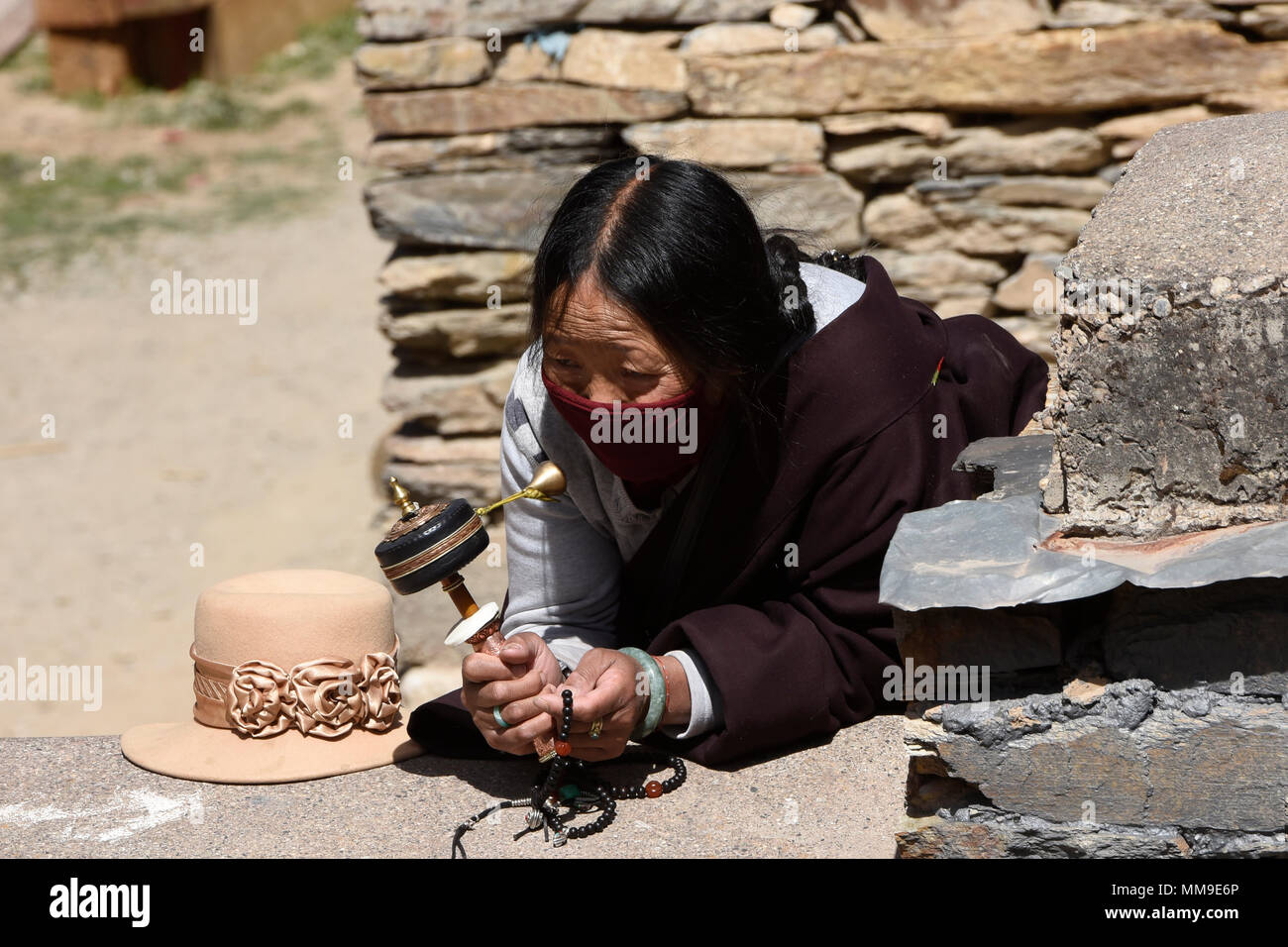 Tibetischen Pilger Spins ein Gebet Rad außerhalb des Heiligen Bakong Schrift Druckmaschine Kloster in Dege, Sichuan, China Stockfoto Tibetischen Pilger Spins ein Gebet Rad außerhalb des Heiligen Bakong Schrift Druckmaschine Kloster in Dege, Sichuan, China Stockfoto