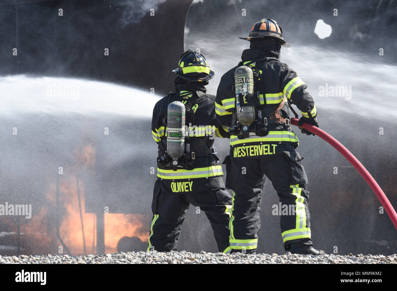 Zwei Mitgliedstaaten Teams aus dem 72. Bauingenieur Squadron, Feuerwehr, zusammen arbeiten, wie Sie das Flugzeug Feuer Trainingsgerät Sept. 13, 2017 Ansatz, Tinker Air Force Base, Oklahoma. Die Feuerwehrleute waren Durchführung jährlicher Rezertifizierung in der realistischen Umgebung. (U.S. Air Force Foto/Greg L. Davis) Stockfoto