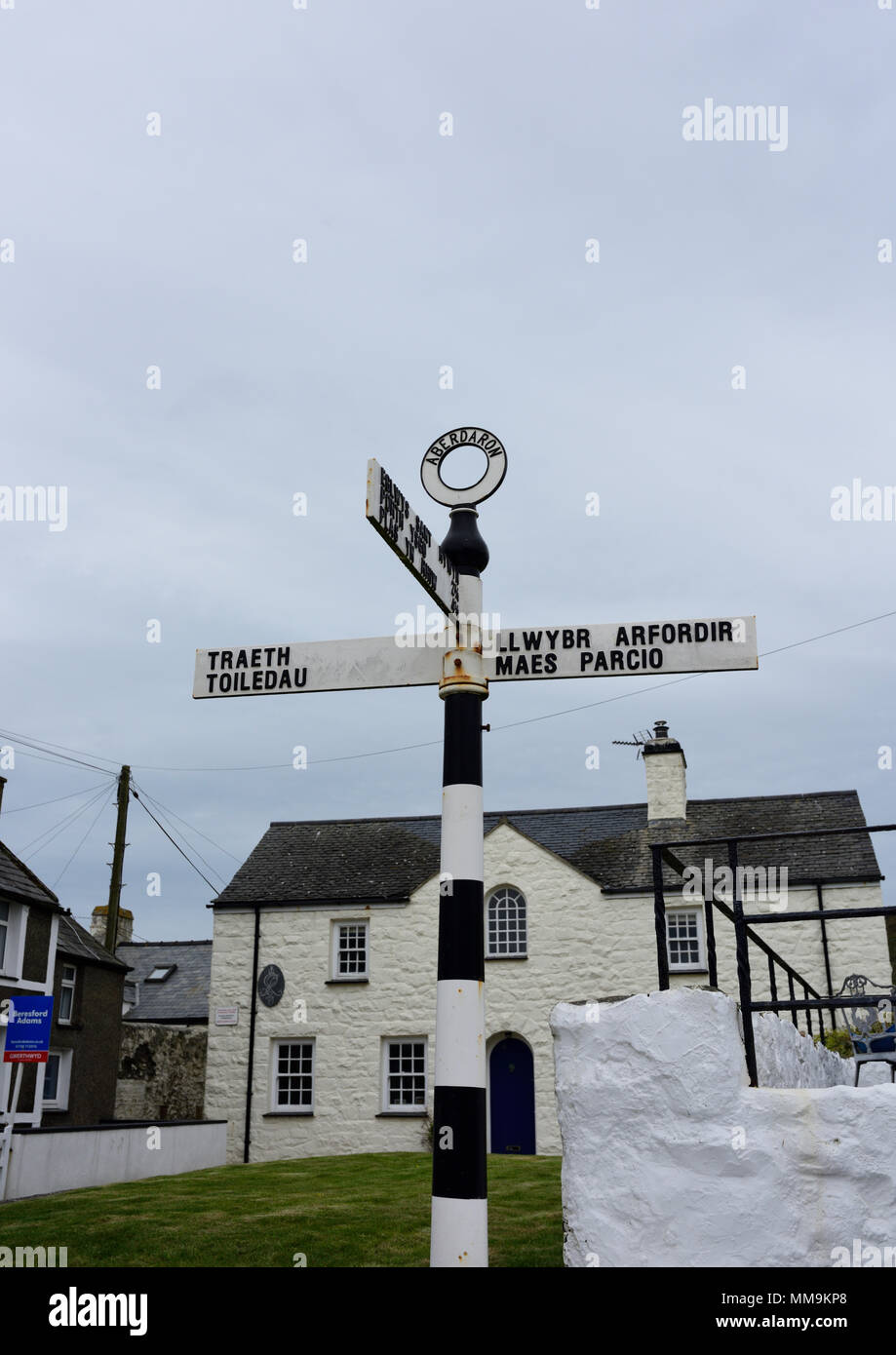 Schwarz-weiß gusseiserne Fingerpost-Beschilderung mit zweisprachigen walisischen und englischen Ortsnamen auf Fingerarmen und Ringfinial in aberdaron, Nord-wales, großbritannien Stockfoto