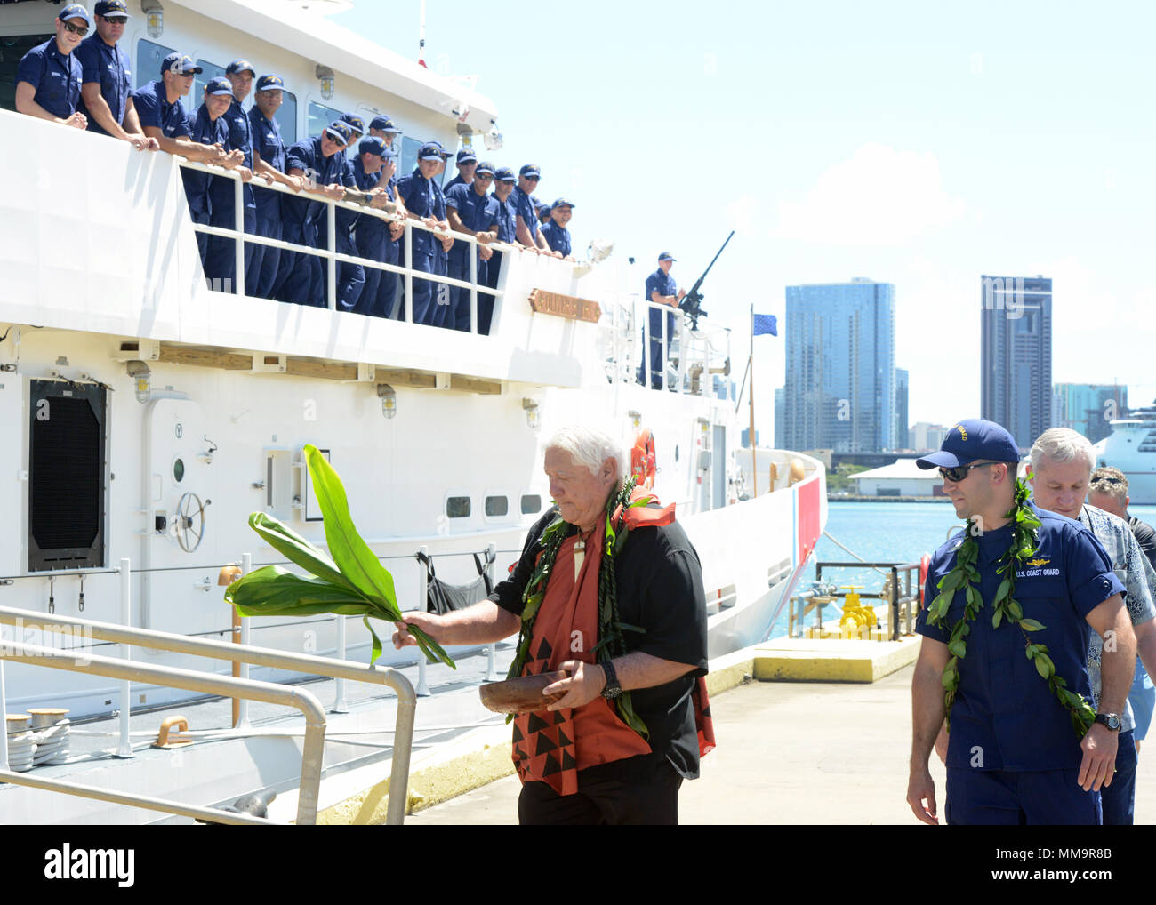 Leighton Tseu, Kane O Ke Kai, gibt einen Hawaiianischen Segen mit Leutnant Kenneth Franklin, kommandierender Offizier der Coast Guard Cutter Oliver Berry (WPC 1124) bei Coast Guard Base Honolulu, Sept. 22, 2017. Die Oliver Berry kam in Honolulu, das erste von drei 154-Fuß-schnelle Reaktion Fräser in Hawaii stationiert. (U.S. Coast Guard Foto von Petty Officer 2. Klasse Tara Molle/Freigegeben) Stockfoto