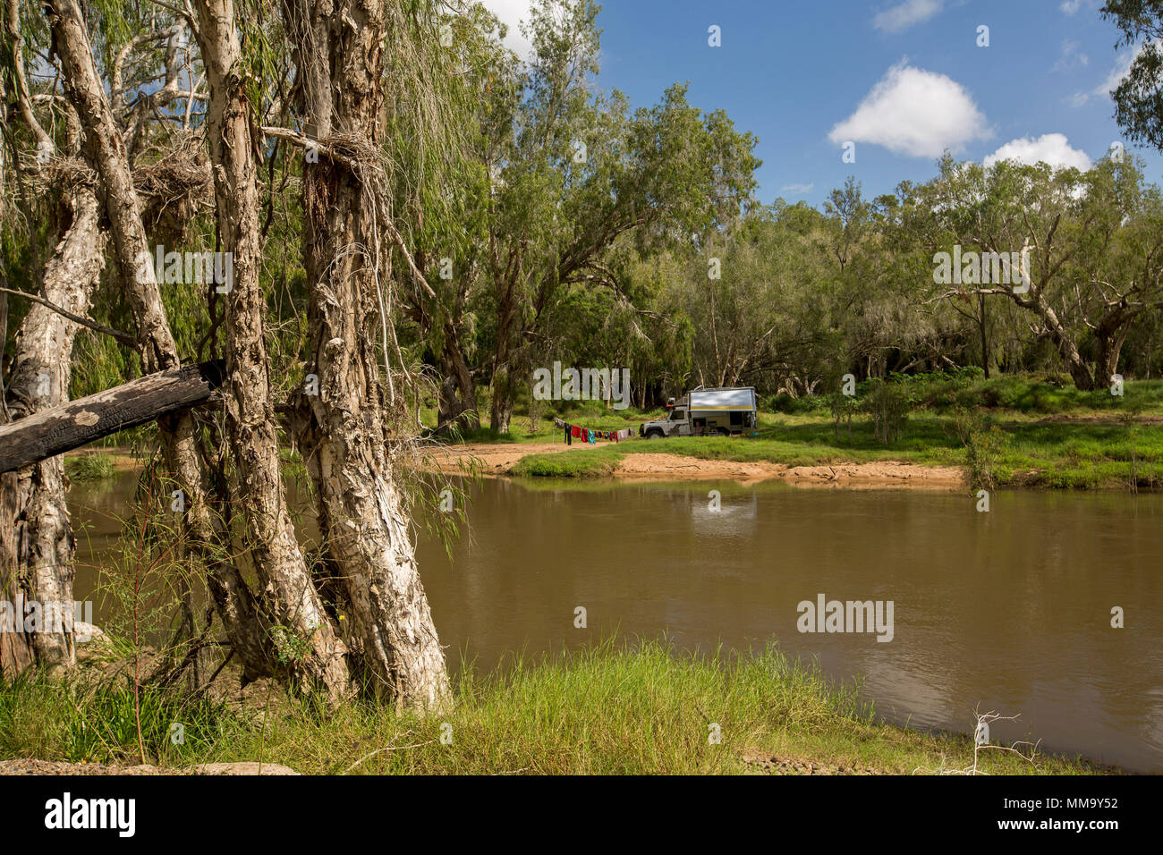 Recreational Vehicle. Land Rover Wohnmobil, Camping in atemberaubender Landschaft auf bewaldeten Bank von Isaac River unter blauem Himmel in Queensland, Australien Stockfoto