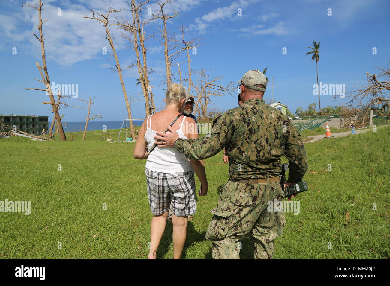 Ein U.S. Navy Sailor guides amerikanischen Bürgern, die eine Evakuierung Control Center in Dominica, Sept. 22, 2017. Us-Mitglieder mit Joint Task Force - Leeward Inseln, eine Evakuierung Control Center am Flughafen Douglas-Charles festgelegt, die in den freiwilligen Evakuierung von US-Bürgern auf Dominica gestrandet nach Hurrikan Maria zu unterstützen. Auf Anfrage der Partnerländer und sowohl das State Department und der US-Agentur für Internationale Entwicklung, JTF-LI hat Flugzeuge und Service Mitglieder zu den Bereichen in der östlichen Karibik bereitgestellt, die von den Hurrikanen Irma und Maria. Die Task Force ist eine in den USA Stockfoto