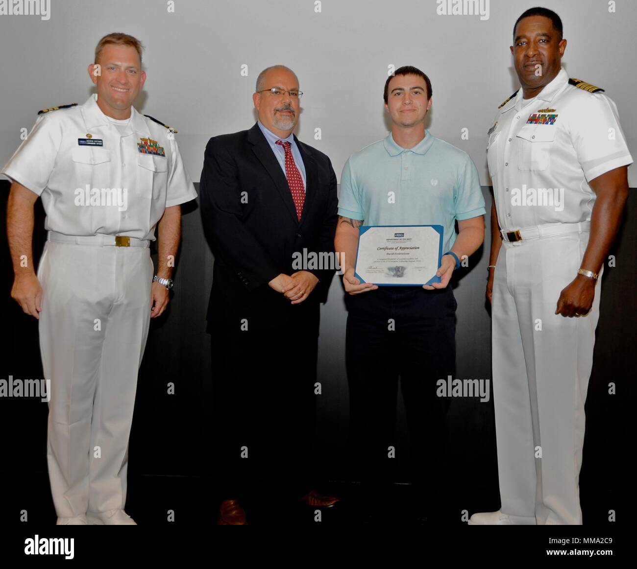 DAHLGREN, VA - David Frederickson erhält seine Urkunde von Naval Surface Warfare Center Dahlgren Division (NSWCDD) Technischer Direktor John Fiore, NSWCDD befehlshabenden Offizier, Kapitän Godfrey 'Gus' Weekes, rechts, und die Bekämpfung der Richtung Activity Dam Hals Kommandierender Offizier Cmdr. Andrew Hoffman am 2017 NSWCDD Akademische Preisverleihung. Frederickson wurde für seinen Master in Betriebswirtschaft von der Old Dominion University anerkannt und gelobt für sein Engagement für die persönliche und berufliche Entwicklung. (U.S. Marine Foto von Patrick Dunn/Freigegeben) Stockfoto