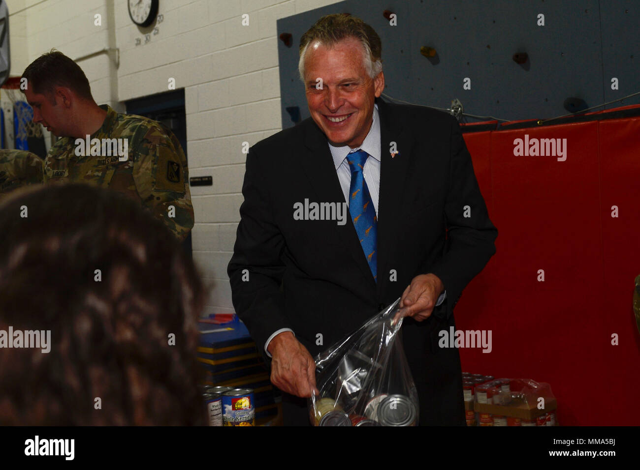 Virginia reg. Terry McAuliffe Futtermittel Lebensmittel Rucksäcke mit allgemeinen Stanford Grundschüler bei einem Besuch in Joint Base Langley-Eustis, Va., Sept. 29, 2017. Dieses Ereignis half Studenten Newport News öffentliche Schulen" die richtige Ernährung zu verstehen und enthalten einen neuen Spielplatz Enthüllung. (U.S. Air Force Foto von Airman 1st Class Kaylee Dubois) Stockfoto