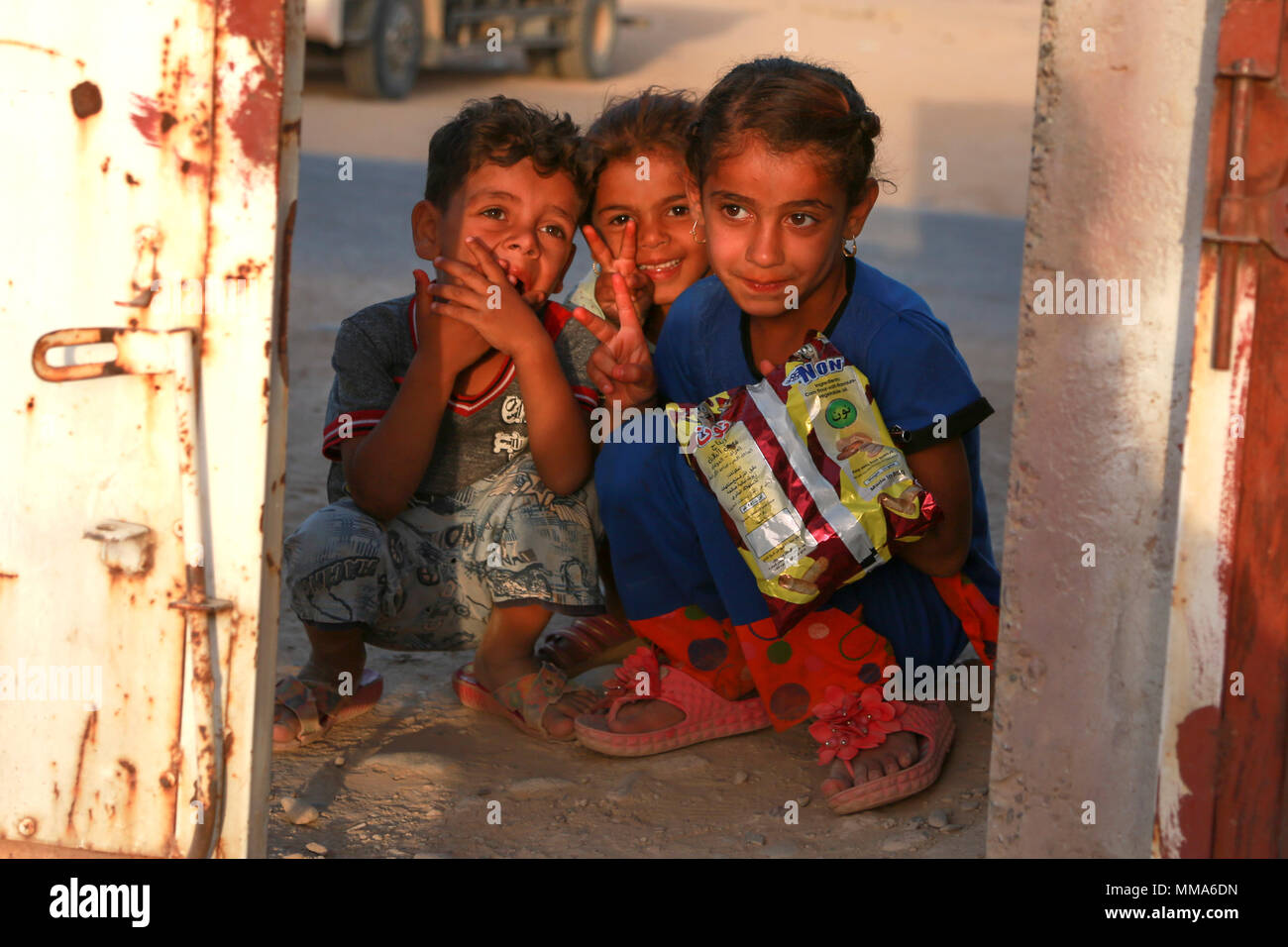Drei Kinder mit Koalition Mitglieder kommunizieren, während ein Gate eines intern Vertriebenen screening Point der Hajj Ali, Irak, 27. September 2017. (U.S. Armee Foto von Sgt. Tracy McKithern) Stockfoto