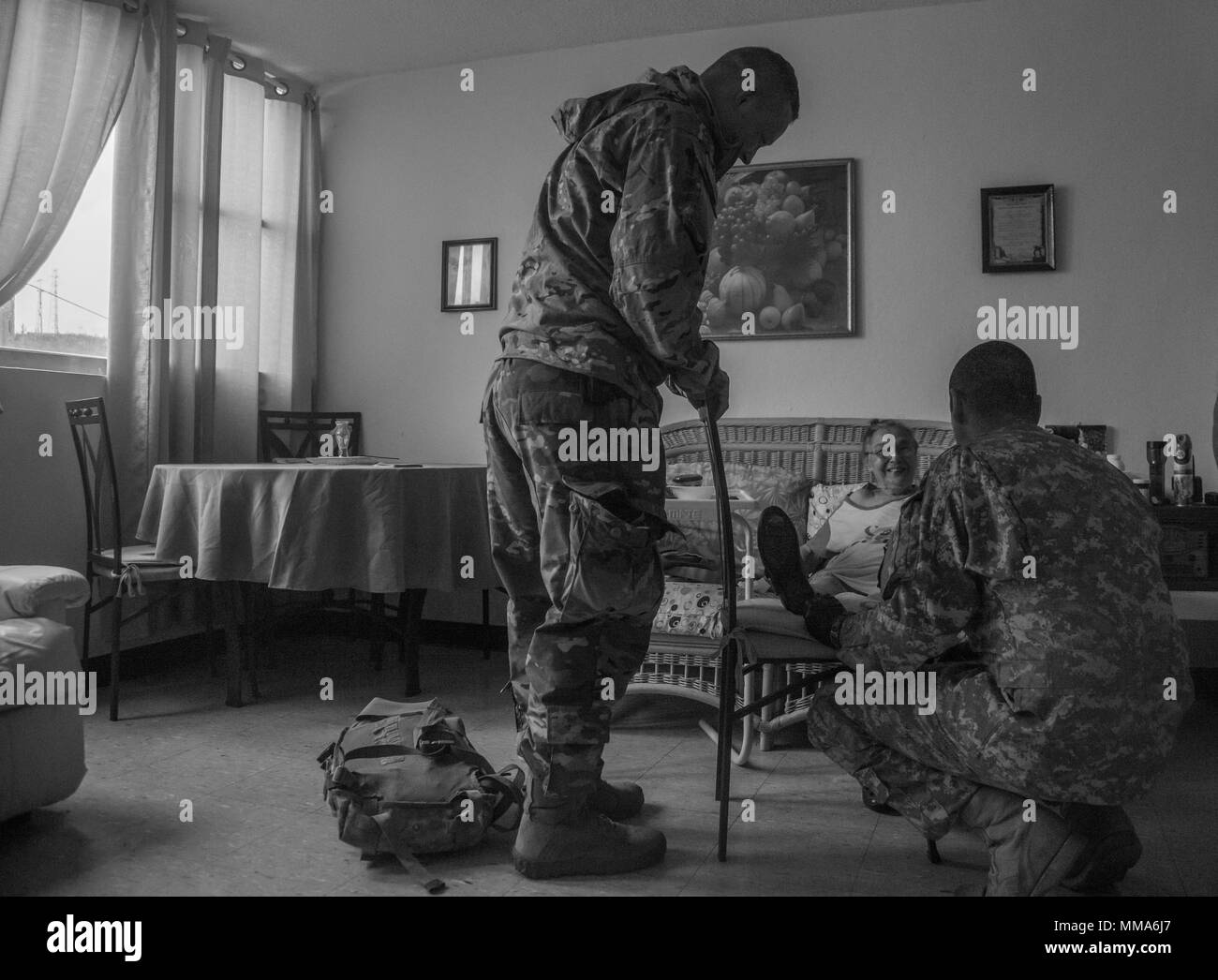 Us-Armee Sgt. Luis Rodriguez (lampenfieber), Flug Medic und Cpt. Benjamin Stork (links), Flug Chirurg, beide Zugeordnet 101 Combat Aviation Brigade (CAB), Luftlandedivision (Air Assault), sprechen mit Georgina Felix, ein Bewohner von Edificio Francisco Doppelpunkt Gordian, ein Heim für Altenpflege, Ceiba, Puerto Rico, Sept. 30, 2017. Die 101 CAB führt medizinische Evakuierung und Katastrophenhilfe FEMA im Wiederherstellungsprozess von Puerto Rico zu unterstützen nach der Verwüstung durch den Hurrikan Maria. (U.S. Armee Foto: Staff Sgt. Pablo N. Piedra) Stockfoto