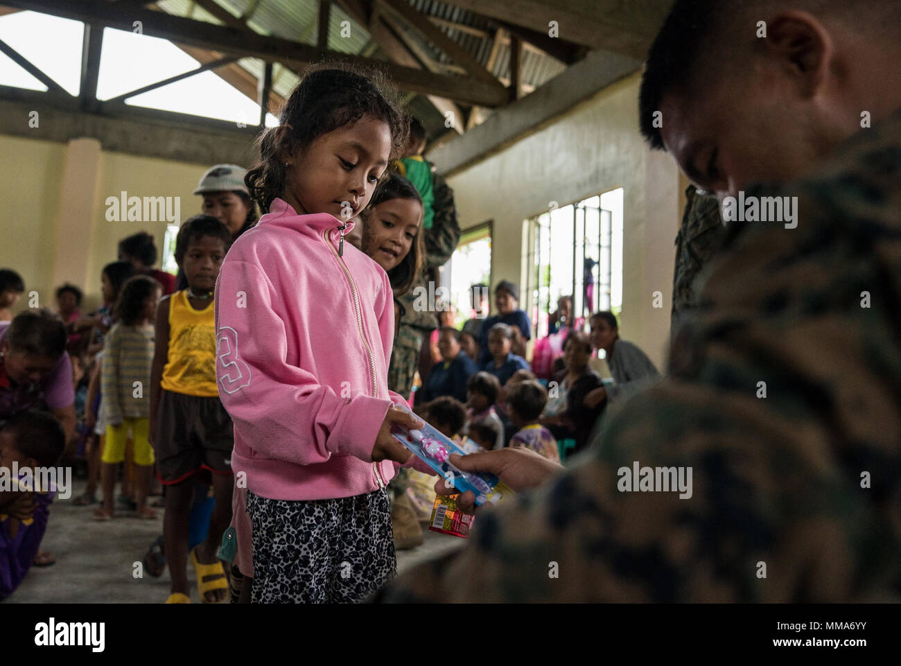 U.S. Navy Chief Petty Officer Jerome Cinco Händen eine Barangay Calabgan Kind eine Zahnbürste während einer Kooperative Gesundheit Engagement zur Unterstützung der KAMANDAG in Casiguran, Aurora, Philippinen, Sept. 29, 2017. KAMANDAG umfasst laufende bilaterale humanitäre und politische Hilfe, die amerikanischen und philippinischen Service Mitglieder einander kennen zu lernen und die lokalen Gemeinschaften zu unterstützen. Cinco ist der ältere Soldat Führer mit Gesundheit Service Support Element, 3. Marine Logistics Group, und ist ein Eingeborener von Tacloban City, Leyte, Philippinen. (U.S. Marine Corps Foto von Sgt. Matthew J. Stockfoto