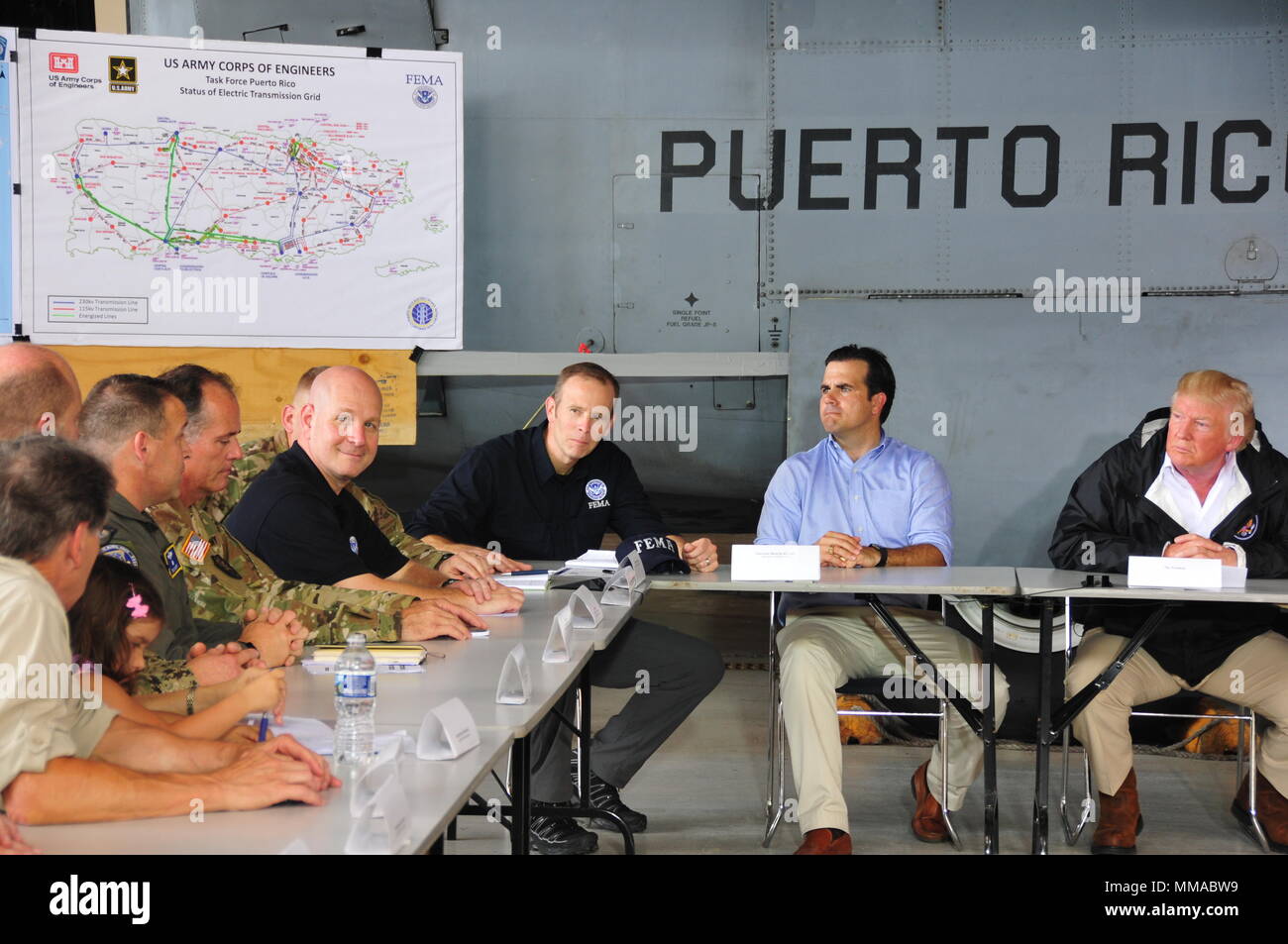 Die FEMA Chief Brock Lange, reg. Ricardo Rossello, und Pres. Donald Trump hören auf Bundes- und lokale Führer in Bezug auf die Schäden und logistische Bewertung der Hurrican Maria, wie sie an Luis Muniz Air National Guard Base, der Heimat der Puerto Rico National Guard. (U.S. Air National Guard Foto vom Kapitän Matt Murphy) Stockfoto