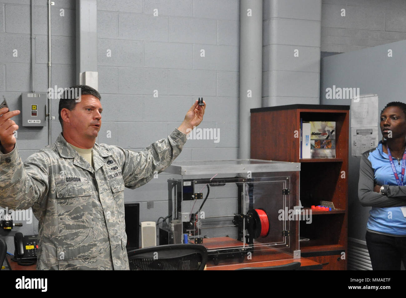 YOUNGSTOWN LUFT FINDEN STATION, Ohio - Air Force Reserve Tech. Sgt. Ross Gordon, ein Metals Technology gesellenprüfung der 910th Maintenance Squadron zugewiesen, zeigt zwei Klammern eine der Fähigkeiten in seinen Arbeitsplatz mit einer Gruppe von mehr als 30 Lehrkräften im Hangar 305 hier, Sept. 27, 2017 zu erklären. Die Halterung in Gordon's rechte Hand produziert wurde durch konventionelle Fertigungsmethoden und die Halterung an der linken Gordon's Hand war auf einem 3-D-Drucker in der 910th Metallverarbeitung Arbeitsplatz hier erstellt. Der Zweck der Erzieher Awareness Event war, damit die Teilnehmer mehr über Ai zu erfahren Stockfoto