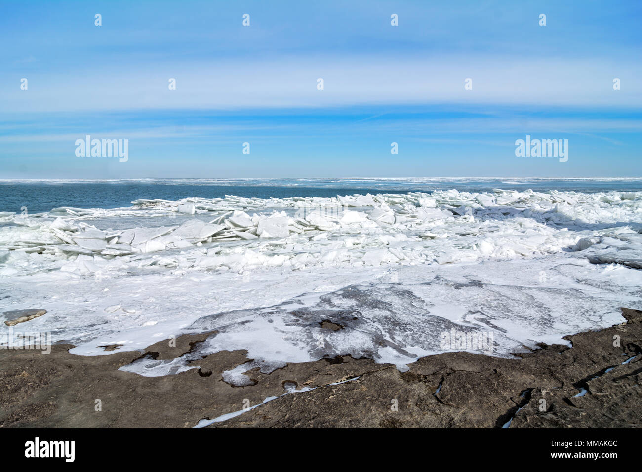 Die eisige Kälte und felsigen Ufer des Lake Erie im Nordwesten von Ohio. Große Blätter von gebrochenem Eis stapeln sich auf den Felsen. Stockfoto