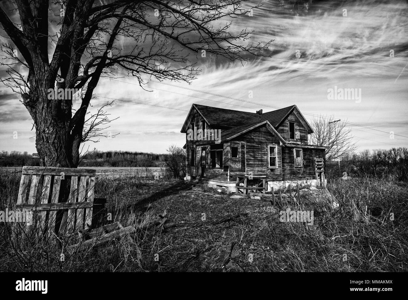 Schwarz-weiß Foto von einem alten unheimlichen verlassenen Bauernhof, verschlechtert sich mit der Zeit und der Vernachlässigung ist. Stockfoto