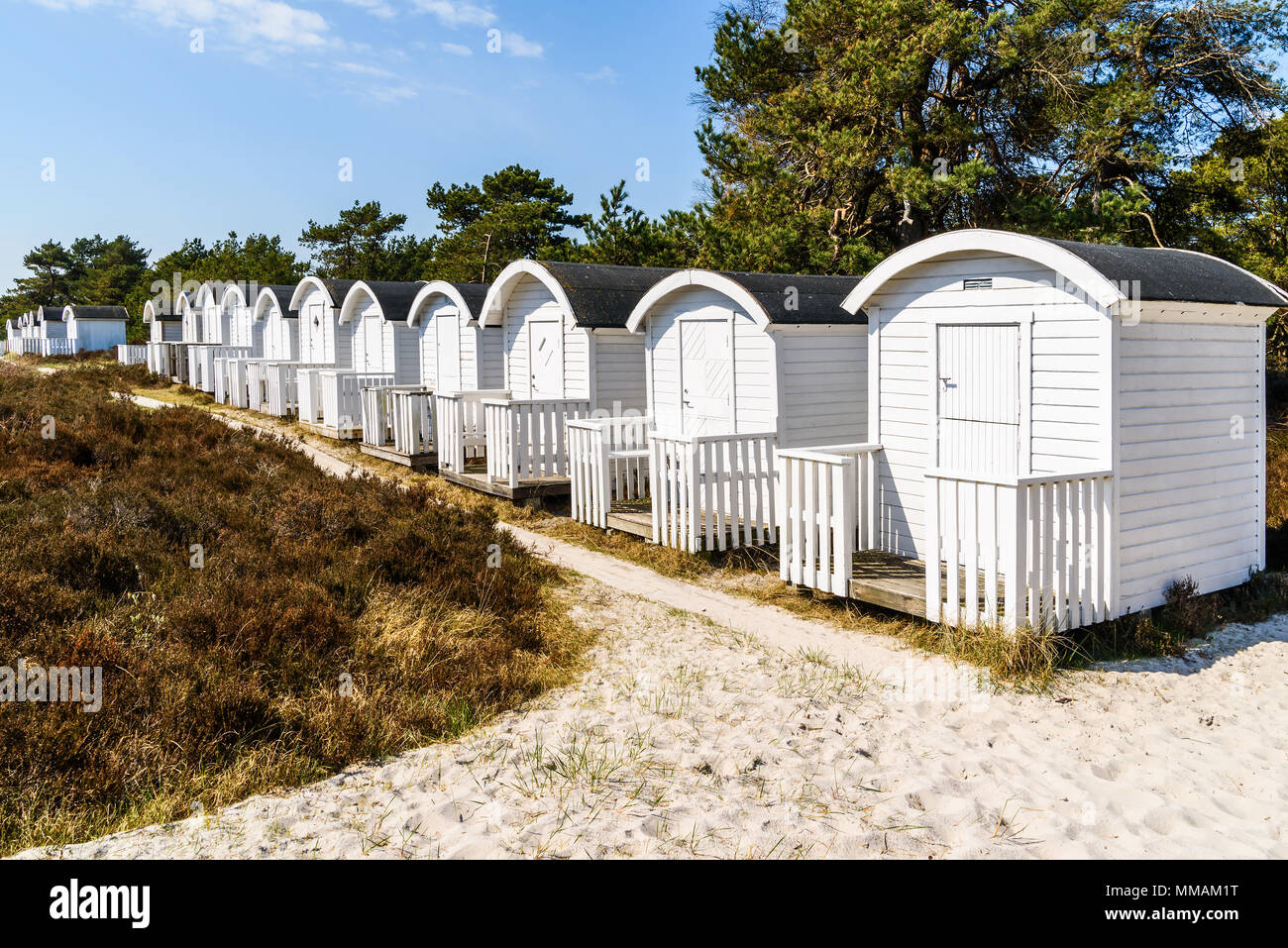 Falsterbo, Schweden - Weiße Meer baden Hütten in einer Reihe von Heather und Sand auf einem sonnigen warmen Tag. Stockfoto