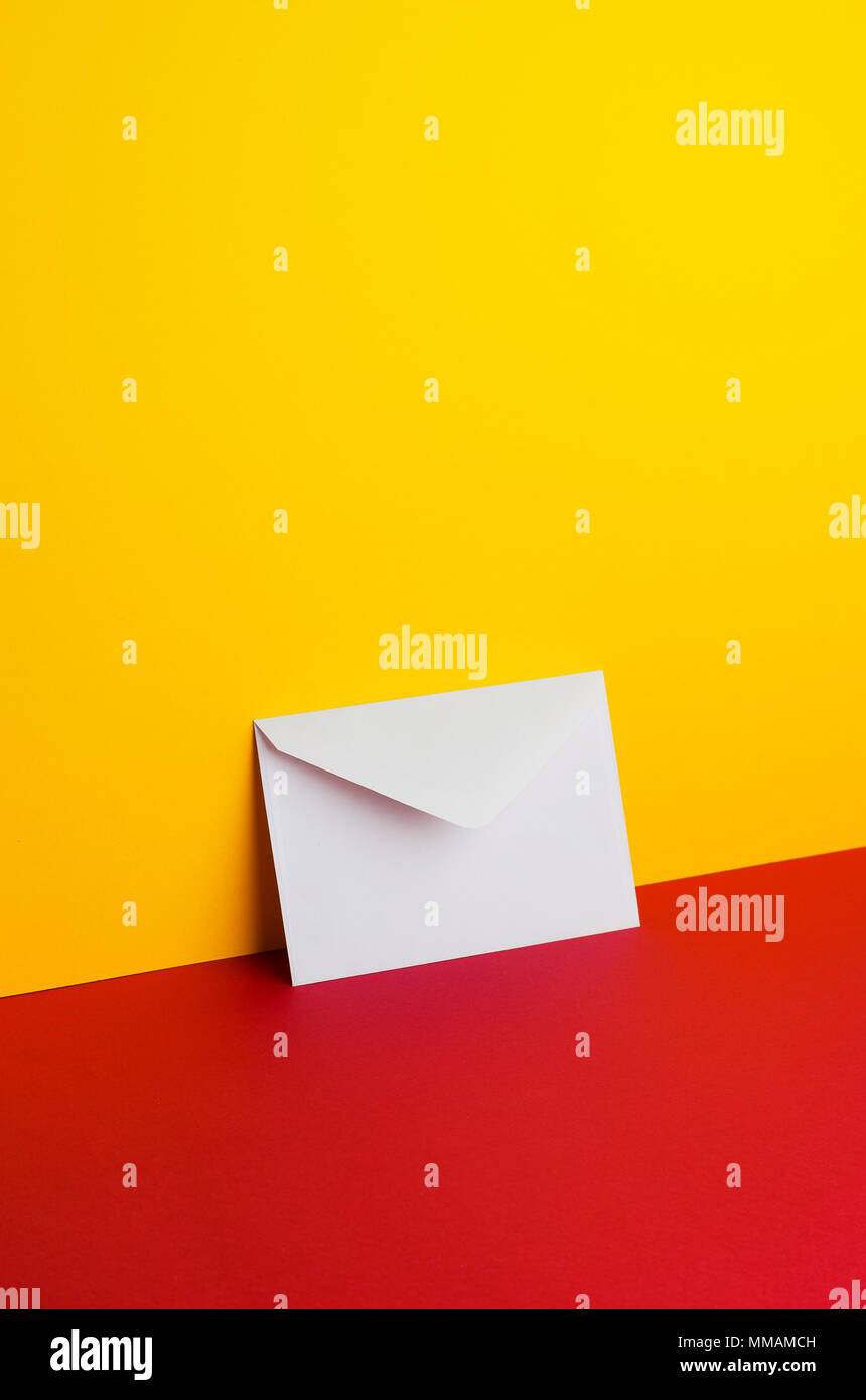 Umschlag gekippt über gelbe und rote Hintergrund mit negativen Raum Stockfoto