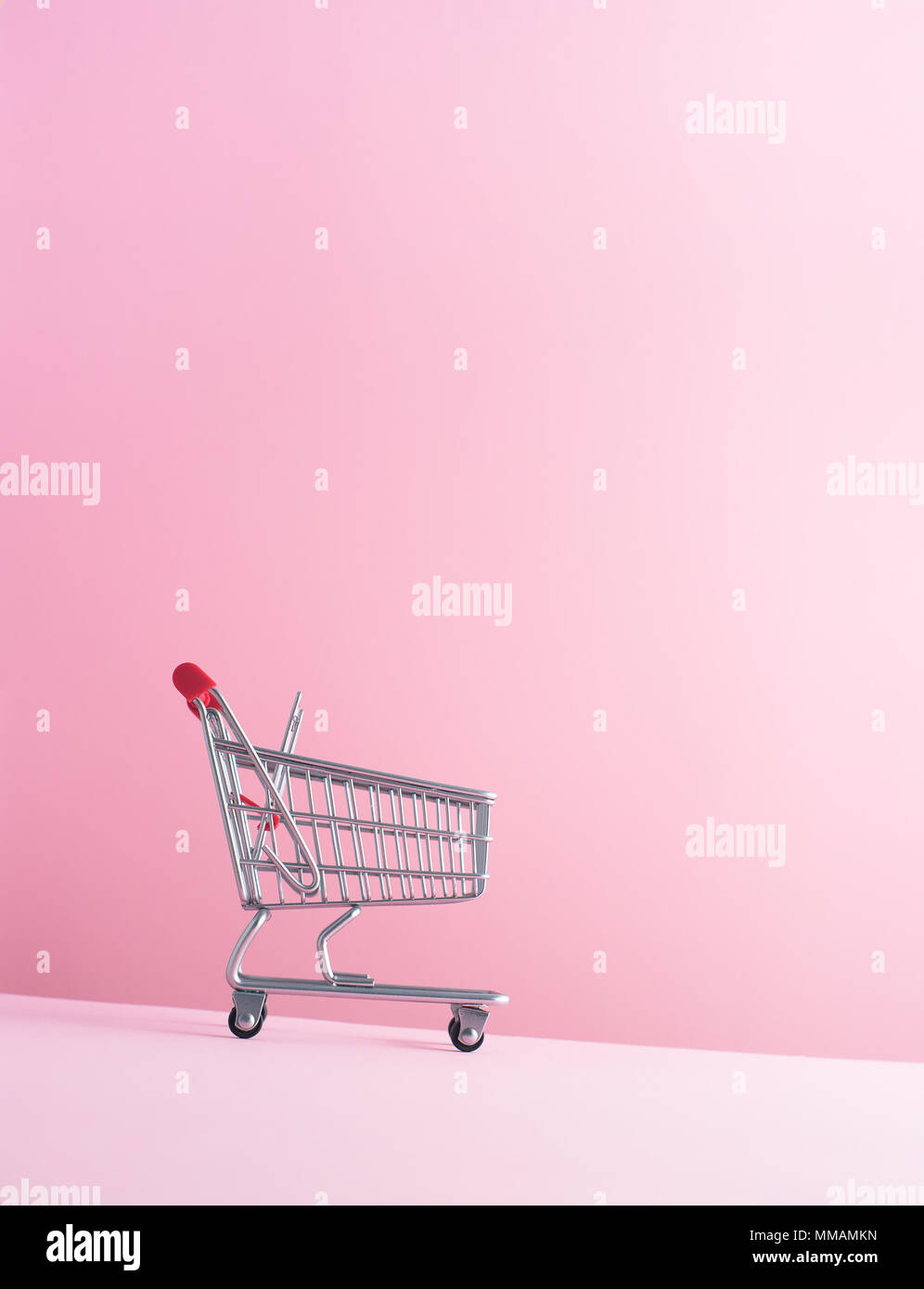 Warenkorb gehen nach unten über rosa Hintergrund Stockfoto