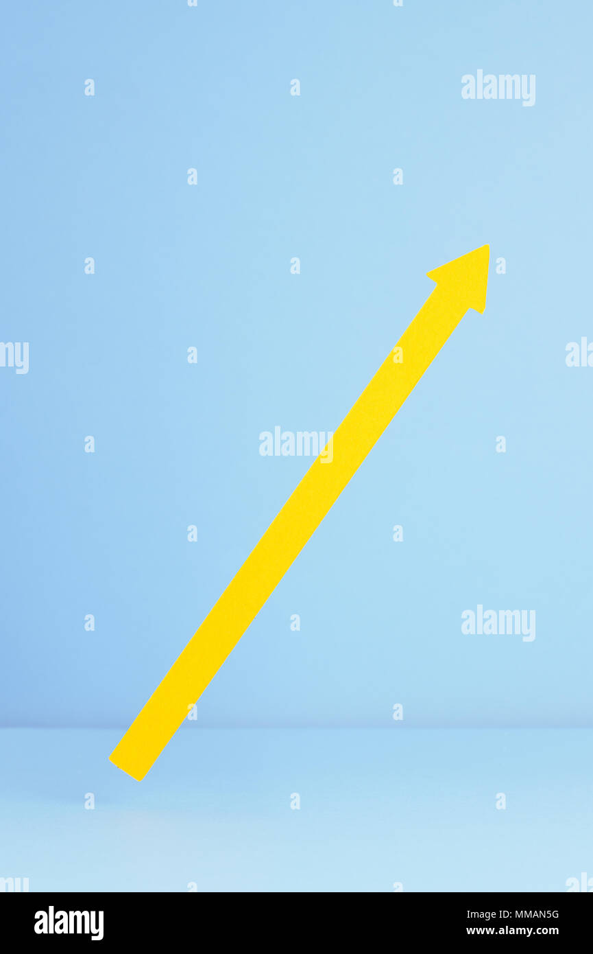 Gelber Pfeil oben poiting über blauer Hintergrund Stockfoto