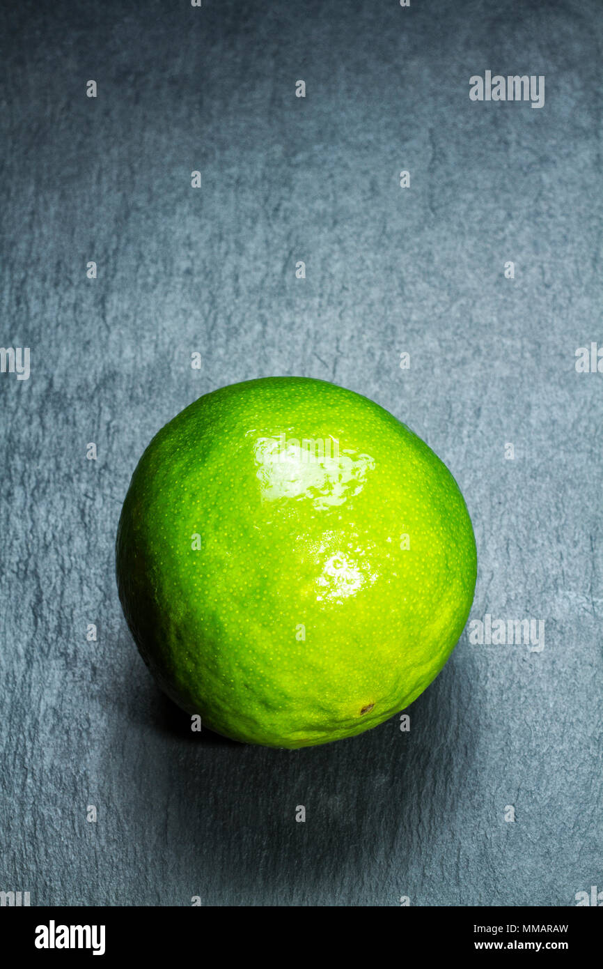 Limette (Citrus aurantifolia) auf einer Schiefertafel. Stockfoto