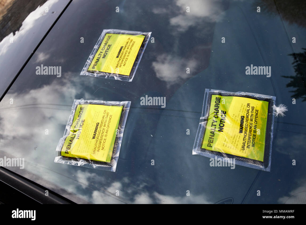 Mehrere strafe Ausleihbenachrichtigungen stecken zu einem Auto Windschutzscheibe in Bath, England, Großbritannien Stockfoto