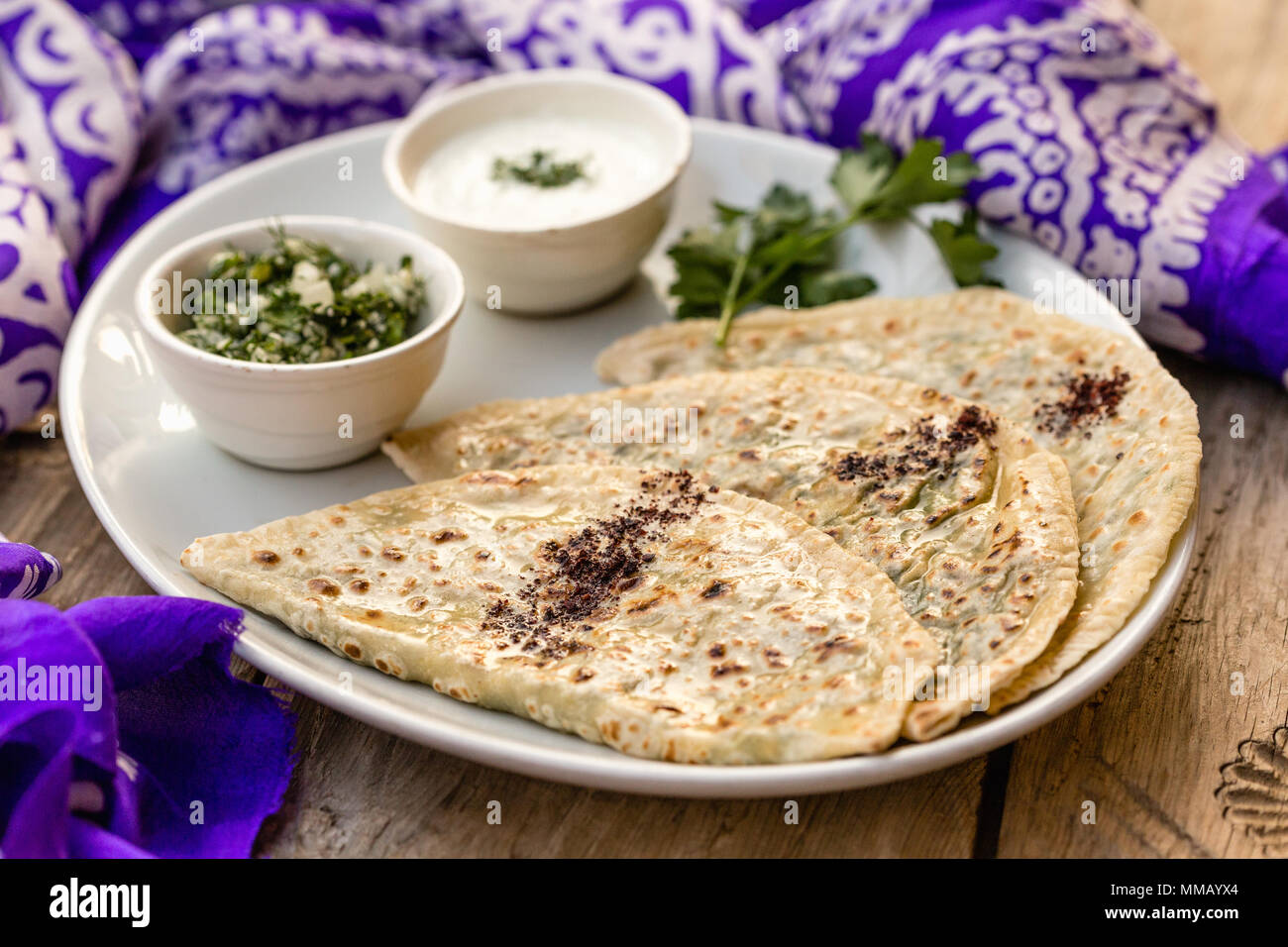 Die Aserbaidschanische traditionelle Küche. Horizontale Schuß von qutabs - Fladenbrot mit Grüns. Mit Joghurt aus weisser Keramik Teller serviert. Stockfoto