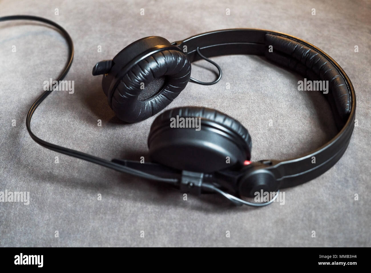 Schwarz audio hipster Kopfhörer mit Kabel liegen auf grauem Hintergrund Stockfoto