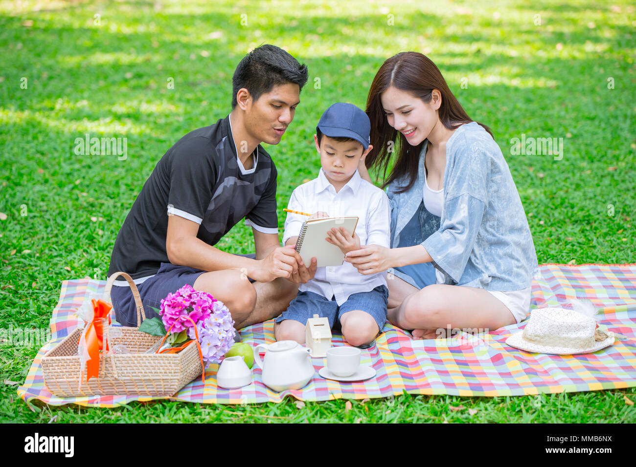Eltern wie Lehrer Konzept: Jugendlich Familie mit einem Kind glücklich Bildung Moment in den Park. Stockfoto