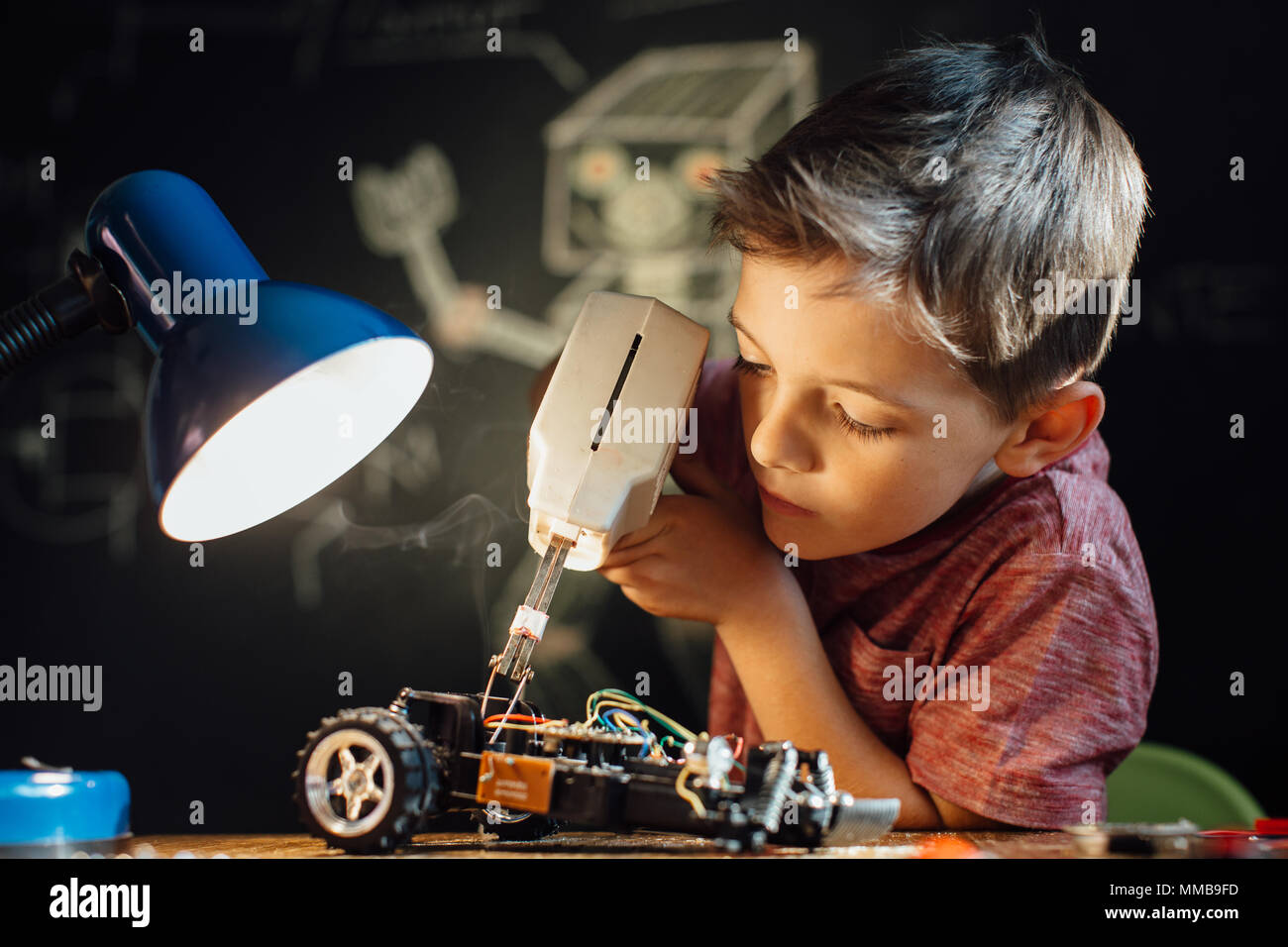 Schwerpunkt junge seinen löten Hobby genießen. Handliche Kind arbeiten auf seinem elektronischen Projekt mit einem Lötkolben. Stockfoto