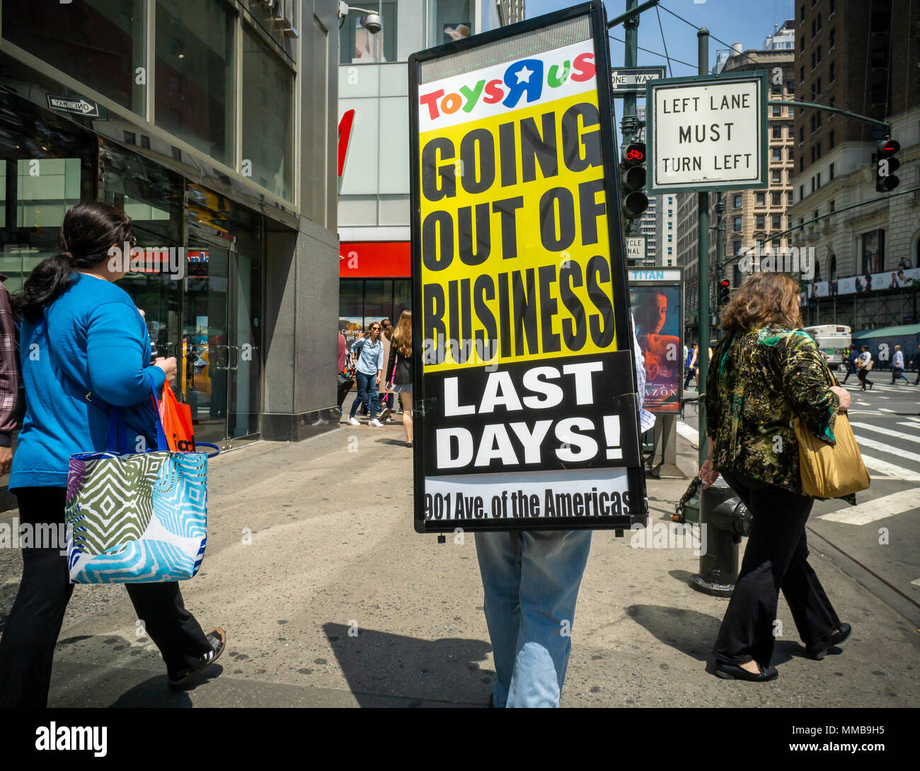 Ein Arbeiter geht Sixth Avenue in New York am Mittwoch, den 9. Mai 2018 tragen ein Schild verkündet, daß der Toys R Us Store geschlossen wird. Toys R Us ist zu liquidieren und schließen alle 735 seiner Stores in den USA. (© Richard B. Levine) Stockfoto