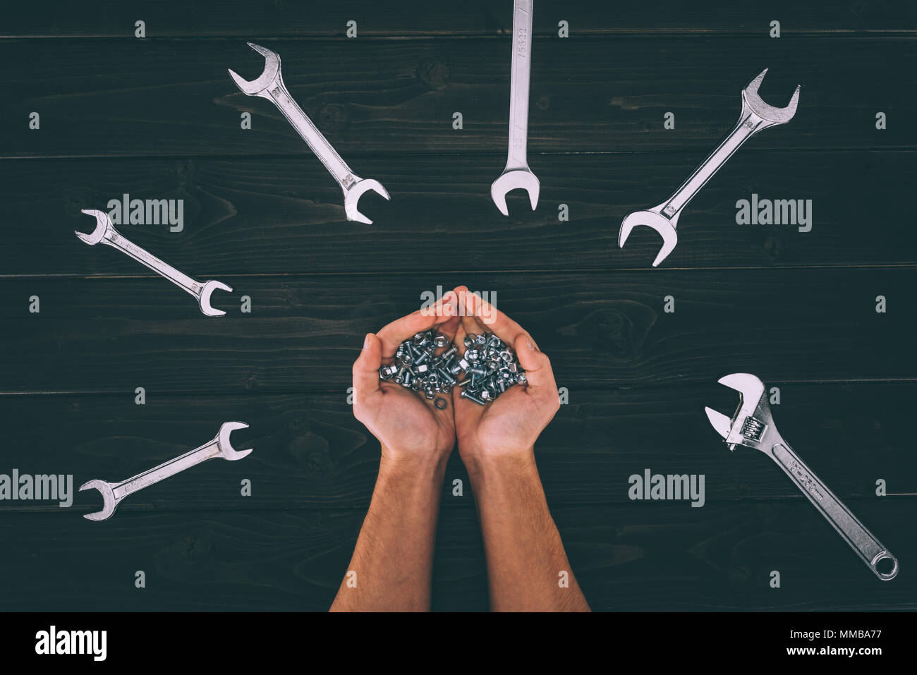 7/8 shot der männlichen Händen hält Tischlerei ausrüstungen mit Schlüssel um auf hölzernen Tischplatte Stockfoto