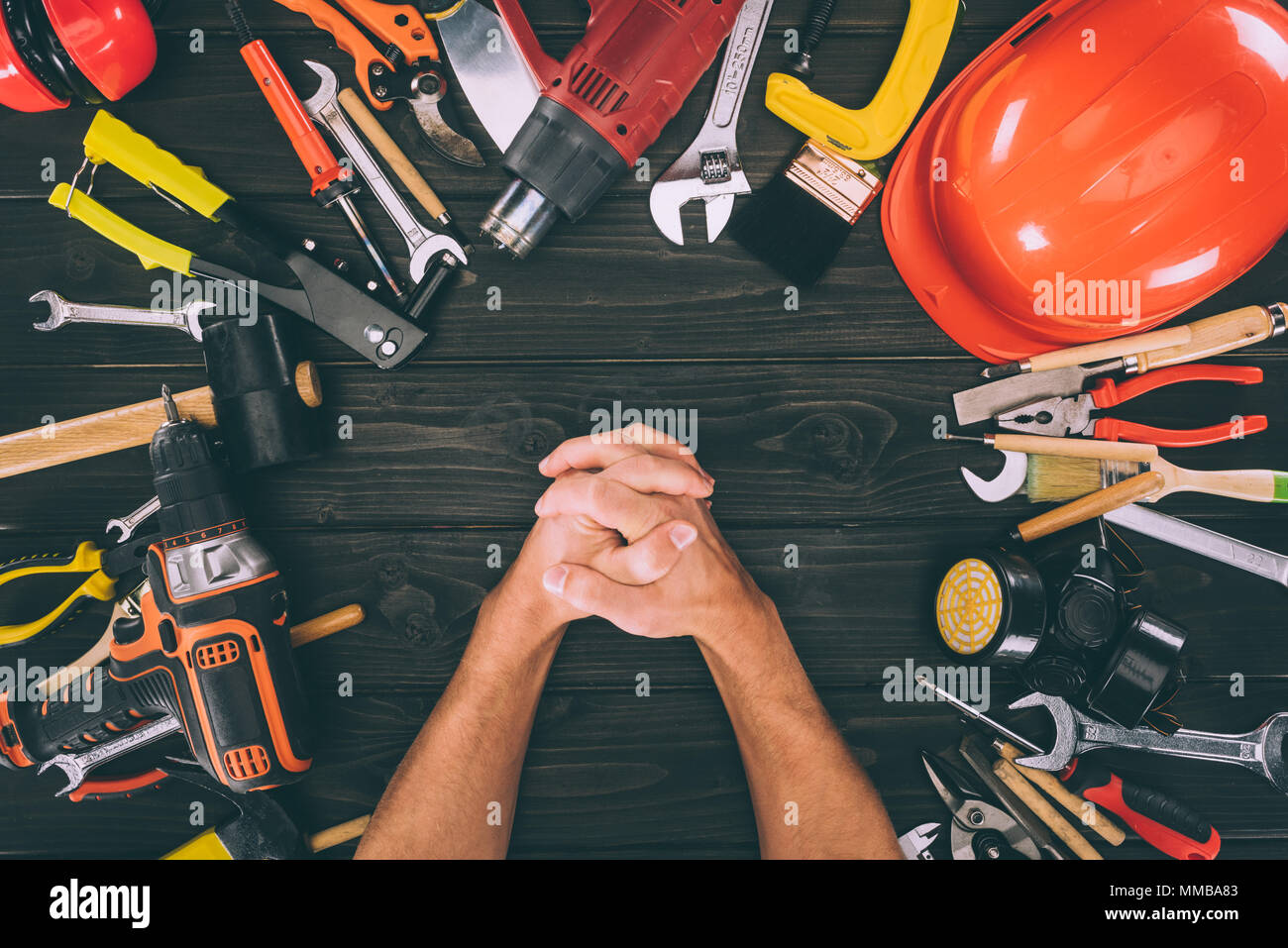 Teilansicht der Hände in der Verriegelung und Tischlerei ausrüstungen Um auf Holz- Oberfläche Stockfoto