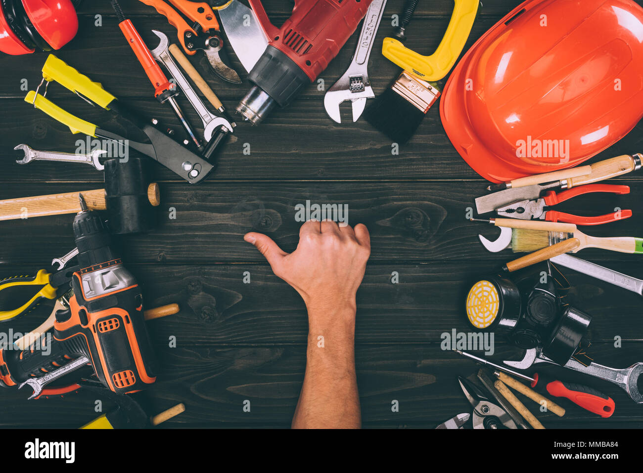 Teilweise mit Blick auf die männliche Hand, Daumen hoch, mit Tischlerei ausrüstungen Um auf Holz- Oberfläche Stockfoto
