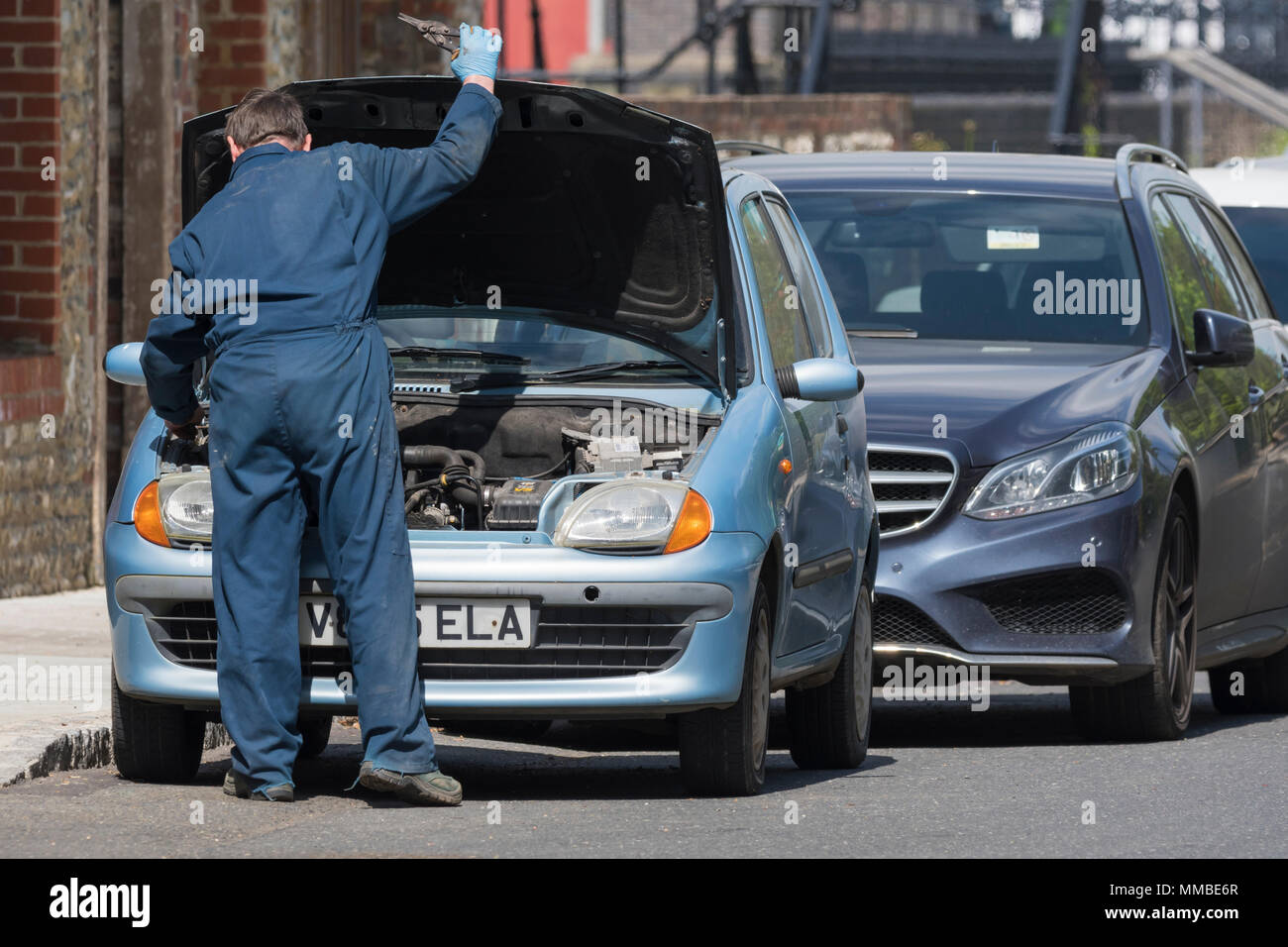 Automechaniker tragen Overalls arbeiten an ein Auto mit der Motorhaube bis in Großbritannien. Stockfoto