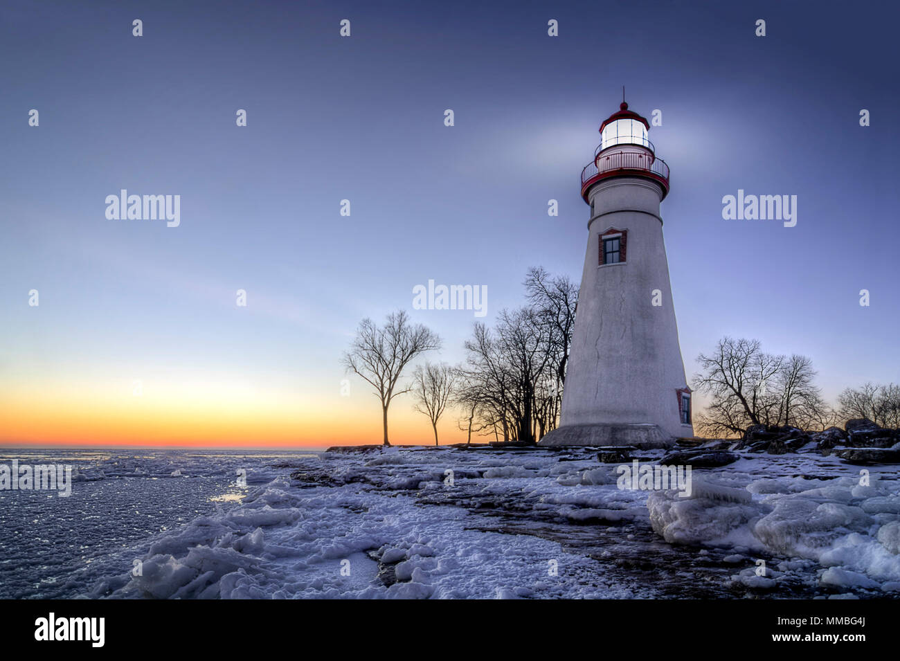 Die historische Marblehead Leuchtturm im Nordwesten von Ohio sitzt entlang der felsigen Ufer des zugefrorenen See Erie. Hier im Winter mit einem farbenfrohen Sonnenaufgang gesehen Stockfoto