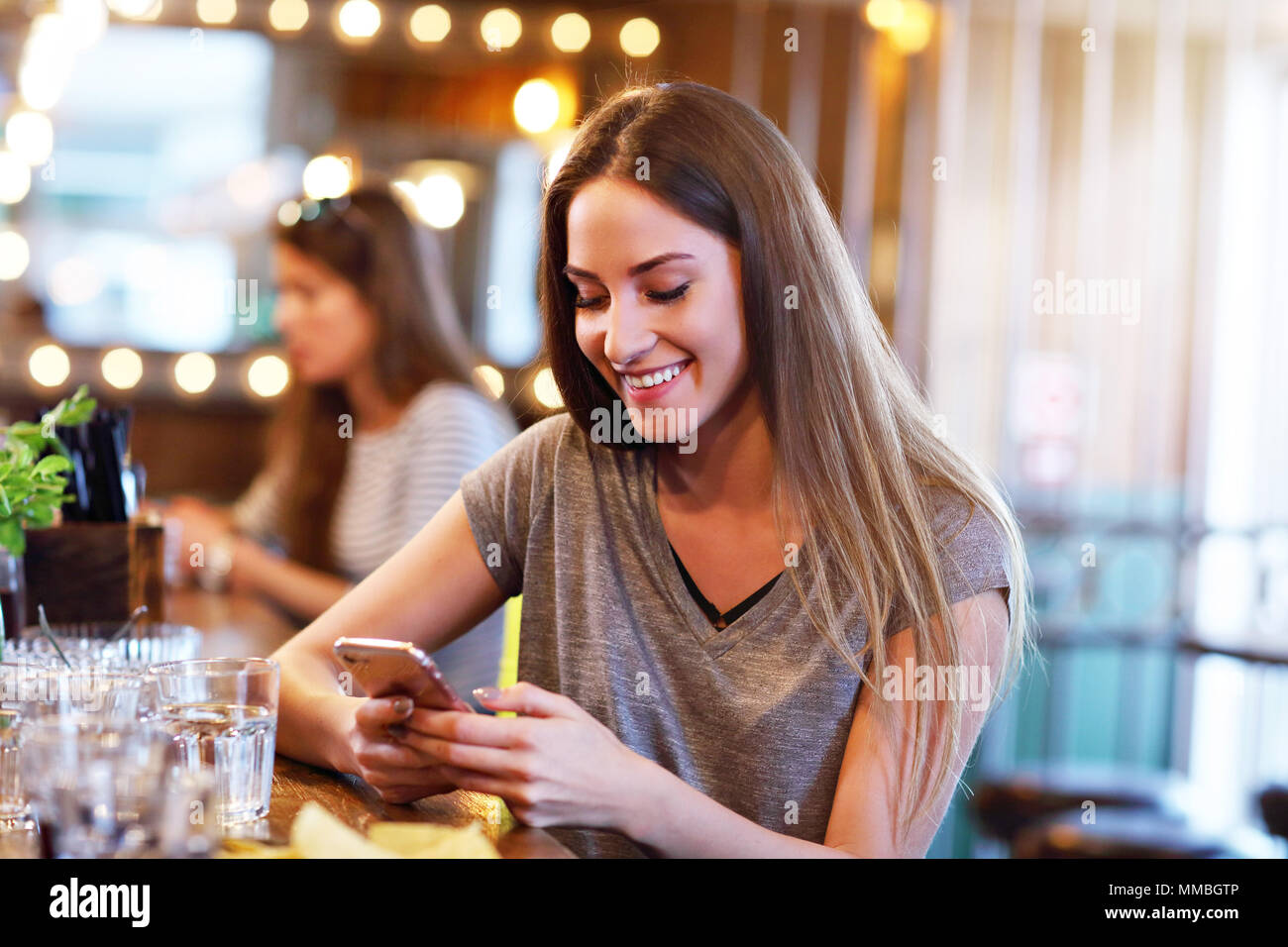 Glückliche Frau sms in Restaurant Stockfoto