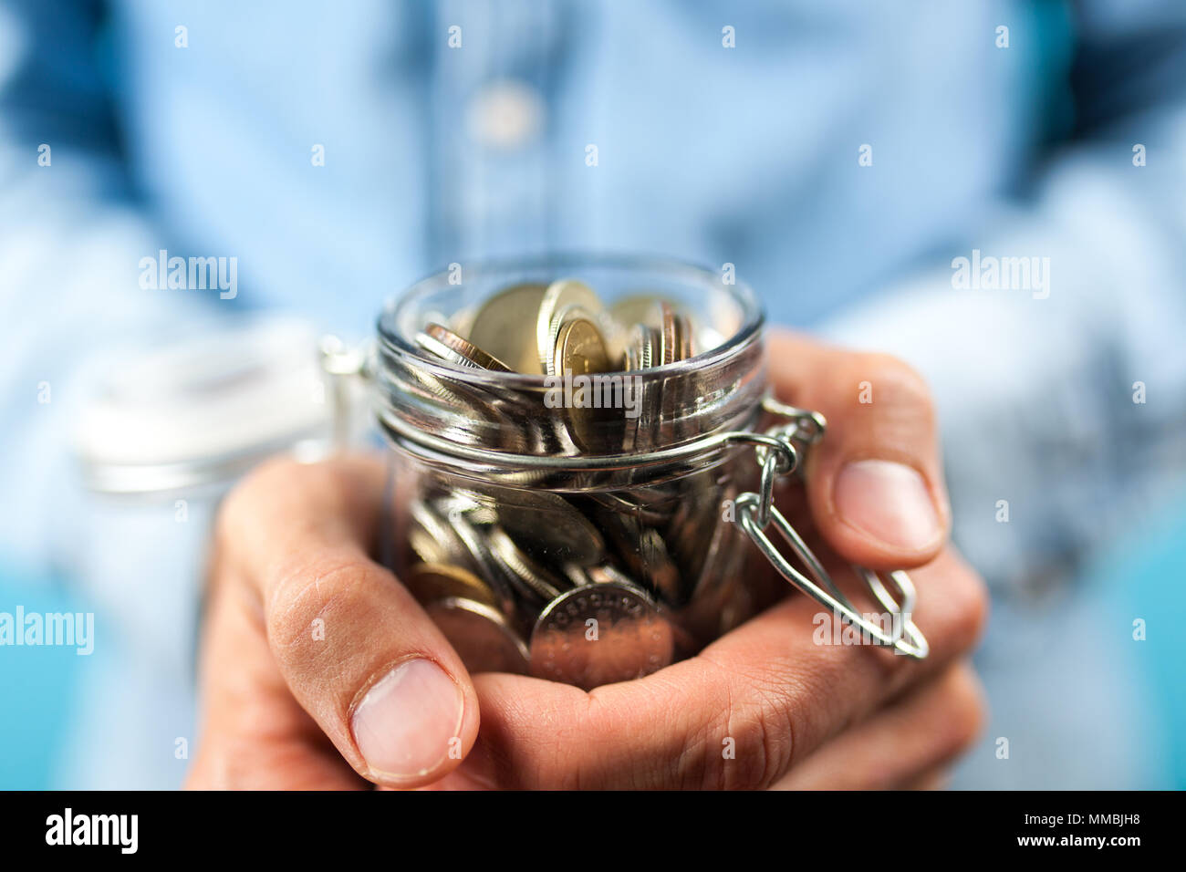 Mann hält eine Münze jar Stockfoto