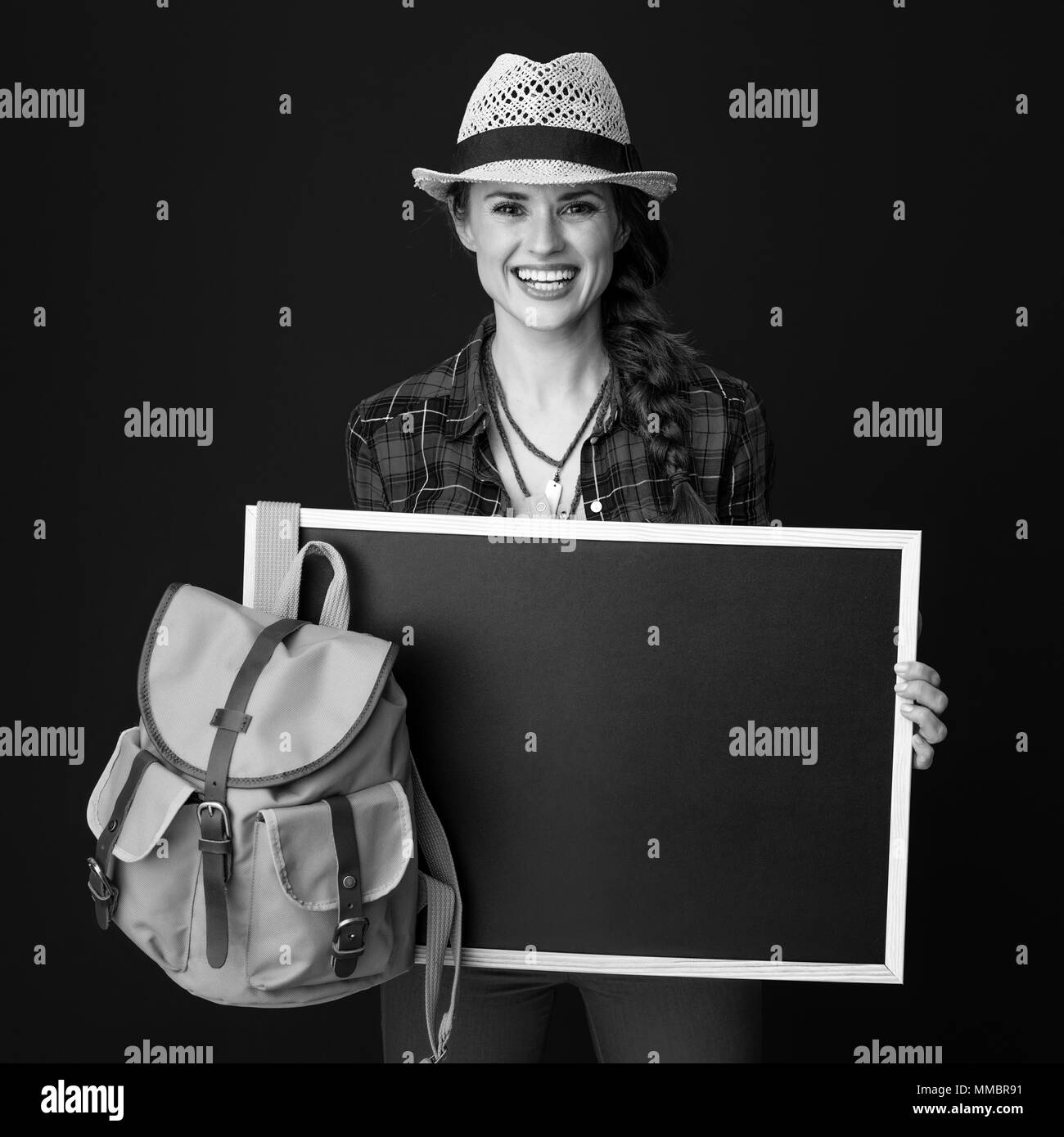 Auf der Suche nach inspirierenden Orten. glückliche junge Frau Wanderer in einen Plaid Shirt, Blank Board auf Hintergrund Stockfoto