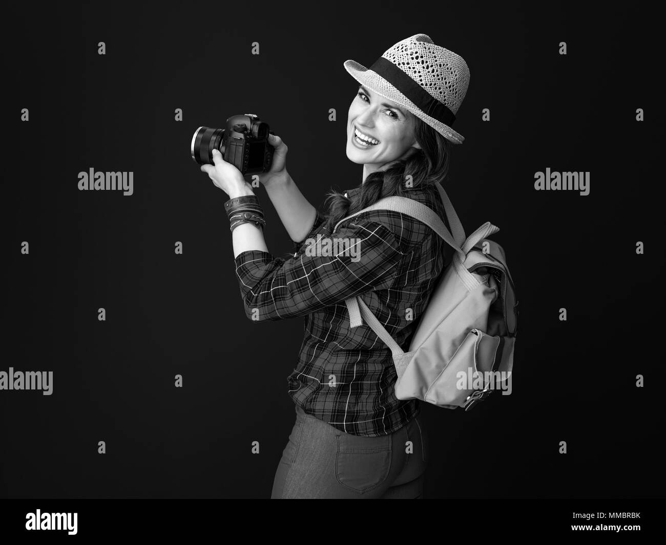 Auf der Suche nach inspirierenden Orten. lächelnden jungen Frau Wanderer in einen Plaid Shirt mit modernen DSLR-Kamera, Foto gegen Hintergrund Stockfoto
