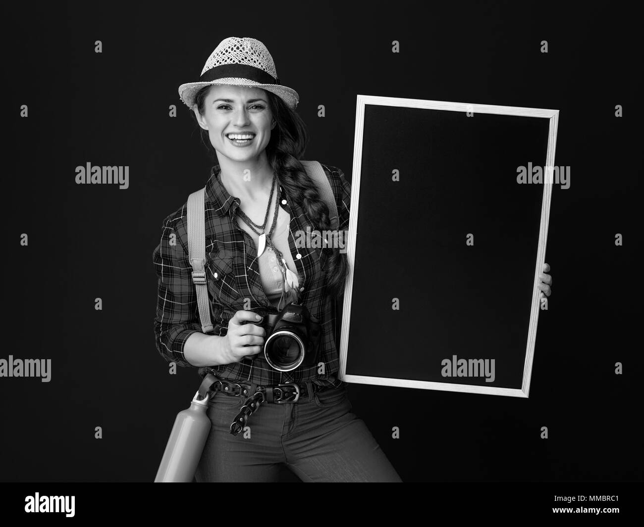 Auf der Suche nach inspirierenden Orten. glückliche junge Frau Wanderer mit Rucksack und Digitalkamera übersicht Tafel gegen Hintergrund Stockfoto