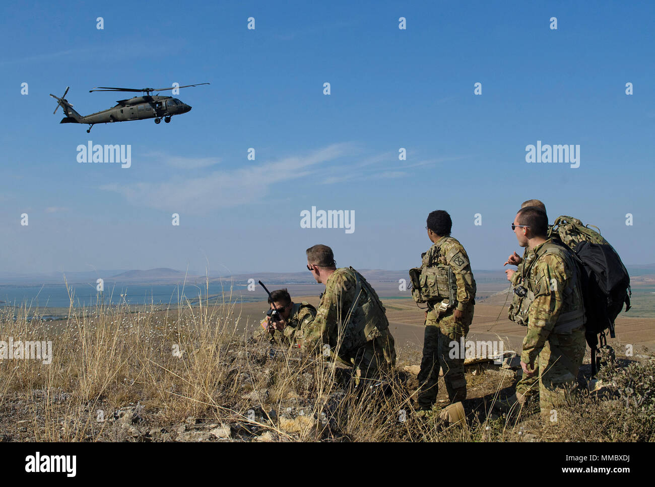 Soldaten mit 2-10 Assault Helicopter Bataillon, 10 Combat Aviation Brigade, beobachten eine UH-60 Blackhawk bieten Antenne Sicherheit für Rumänische pararescue Kräfte in Babadag, Rumänien, 3. Oktober 2017. Der Zweck dieser simulierten abgestürzten Flugzeuge Ausbildung Übung war von Fähigkeiten im Überleben, Steuerhinterziehung, Widerstand und Flucht Verfahren bauen, 10 CAB Soldaten mit dem csel System vertraut zu machen und Personal zu entwickeln Recovery Verfahren zwischen den NATO-Verbündeten. (U.S Armee Foto von Sgt. Justin Geiger) Stockfoto