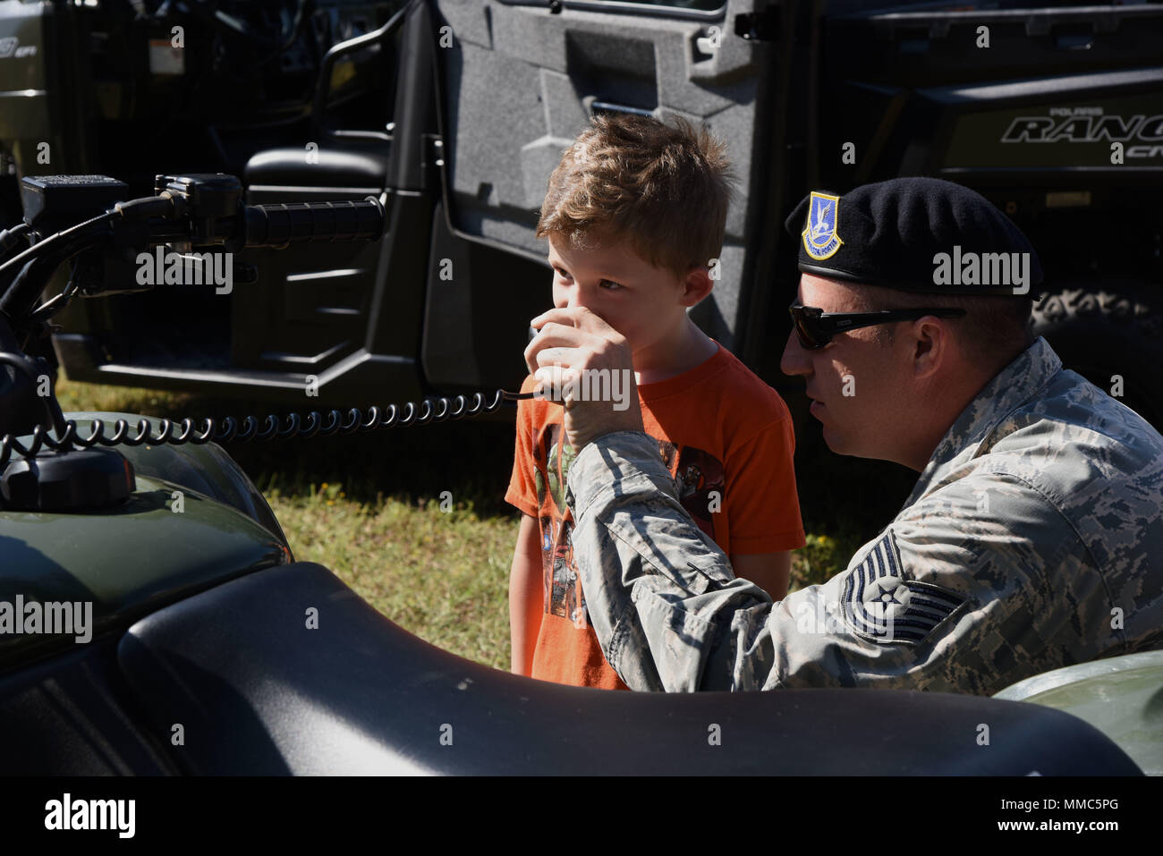 Tech. Sgt. Jared Miller, 81st Security Forces Squadron Einheit Abteilungsleiter, lässt Ean Töpfer, Sohn des Airman 1st Class James Töpfer, 334 Training Squadron student, sprechen, in ein Land Mobile Radio während einer Exkursion in die 81St SFS für Home Kinder Sept. 29, 2017 geschult, auf Keesler Air Force Base, Texas. Der 81st SFS eine militärische Gebrauchshund Leistung, eine Waffen Sicherheit Demonstration und eine Tour durch ihre Patrouille Fahrzeugen. (U.S. Air Force Foto von Kemberly Groue) Stockfoto