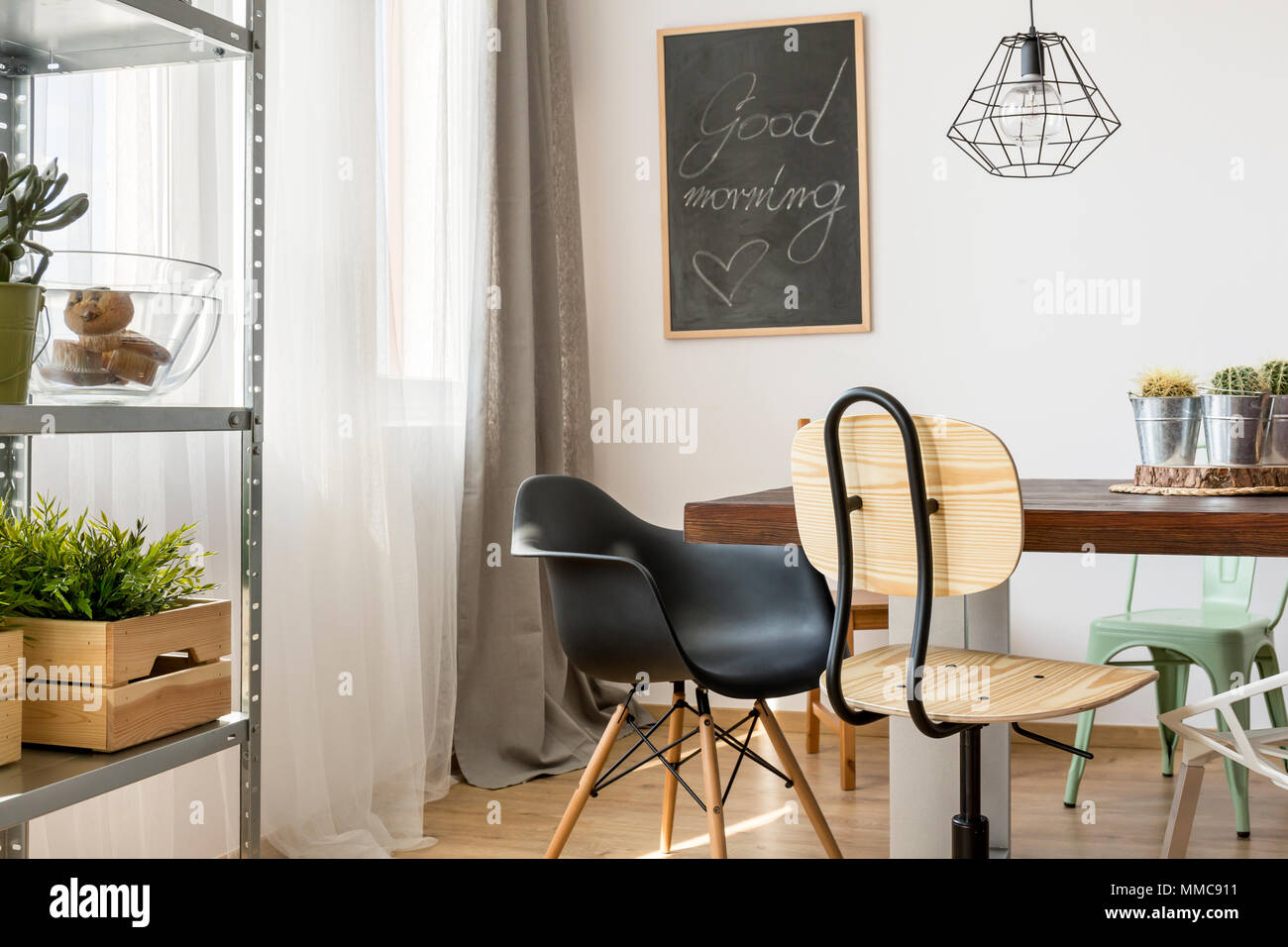 Helle Zimmer mit gemeinsamen Tisch, Stühle, Lampen und Regale Stockfoto