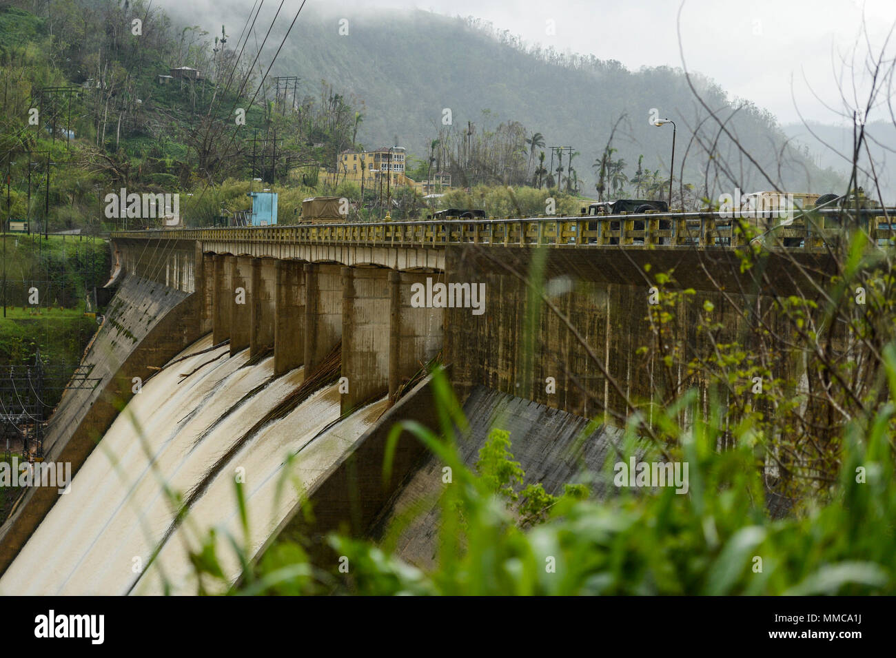 Puerto Rico Armee Reservisten, der U.S. Coast Guard Investigative Service Agenten, der U.S. Coast Guard taktische Strafverfolgung Teammitglieder, Puerto Rico Treasury Agenten und ein Puerto Rico Ports Authority Agenten überqueren Sie die Las Dos Bocas dam bei gleichzeitiger Bereitstellung von Hilfe für die durch den Hurrikan Maria in den Bergen rund um Utuado, Puerto Rico, 12.10.2017, betroffen. Die Federal Emergency Management Agency und seiner föderalen Partner weiterhin 24-Stunden-Betrieb Missionen zur Unterstützung der Betroffenen durch den Hurrikan Maria zu führen. (U.S. Air Force Foto von Master Sgt. Joshua L. DeMotts) Stockfoto