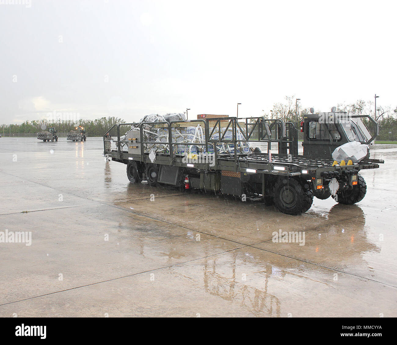 Citizen-Airmen vom Puerto Rico Air National Guard arbeit Ladung von Luftfahrzeugen, die in einem schweren Regen an Muniz Air National Guard Base, Puerto Rico, 16. Okt. 2017 entladen. Muniz ANGB ist eine primäre Drehscheibe für die Bewegung von Hilfsgütern wie die Nationalgarde und anderen Agenturen weiterhin die Wiederherstellung der Insel von Hurrikan Maria zu unterstützen. (U.S. Air National Guard Foto von Tech. Sgt. Dan Heaton) Stockfoto