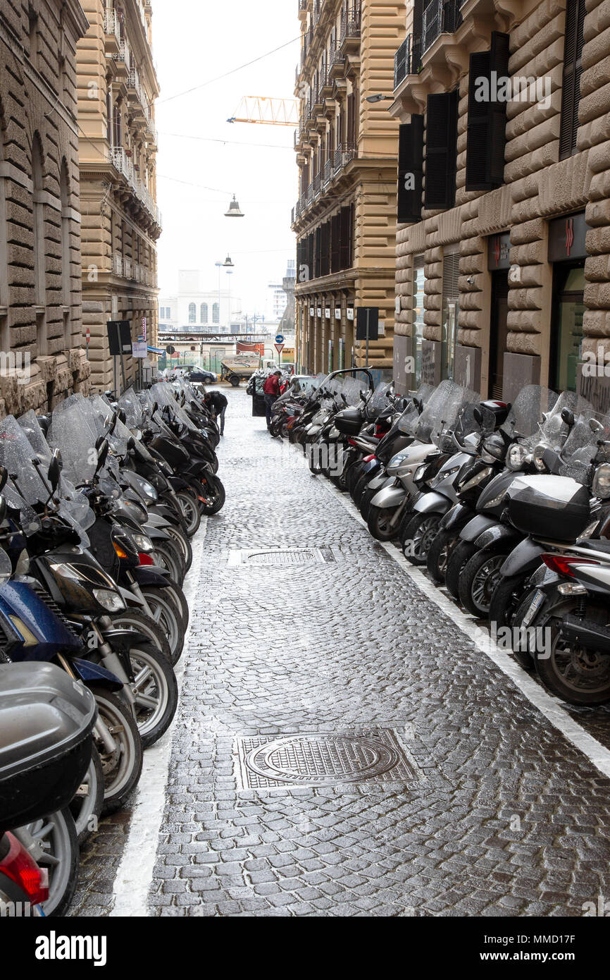 Reihen von Motorrollern in einem Neapel Seitenstraße geparkt in Italien Stockfoto