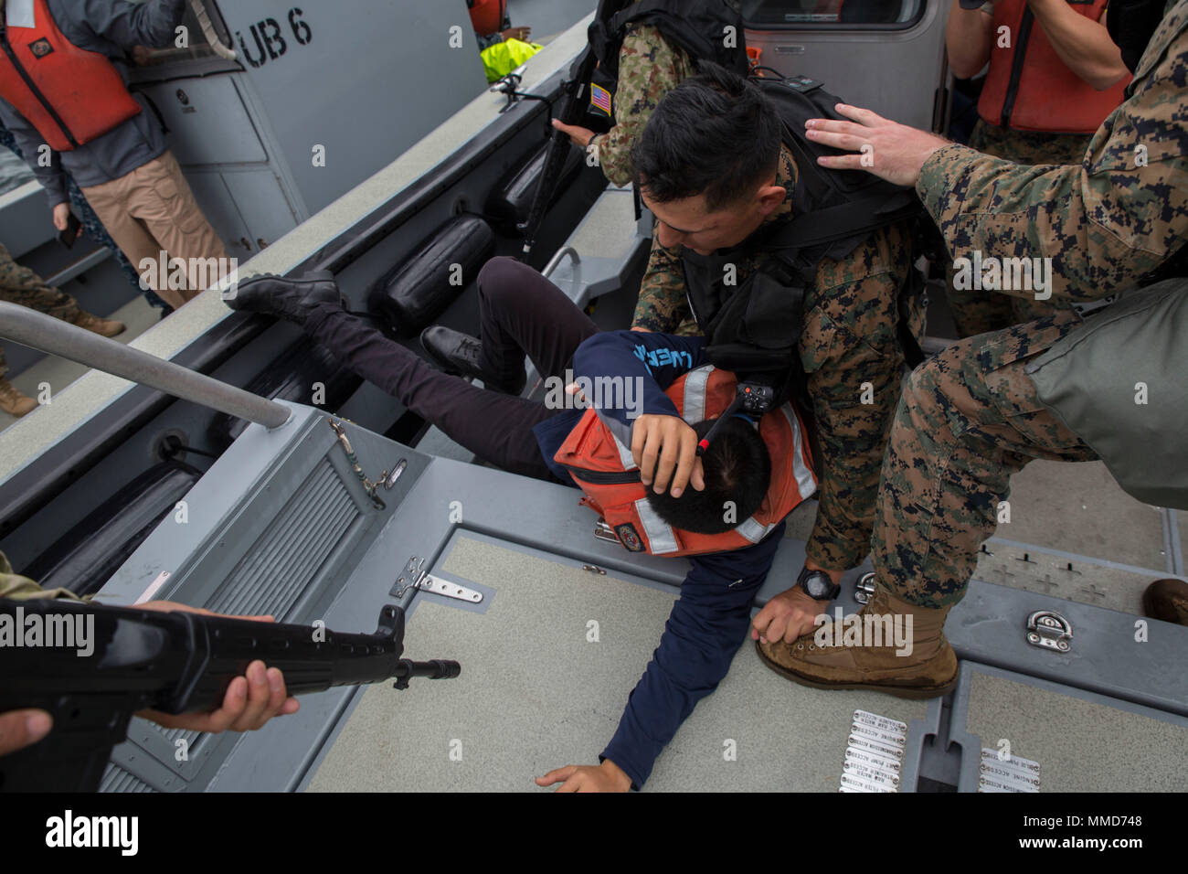 Us-Marines und Japan Masse Verteidigung-kraft Soldaten begreifen eine simulierte Verdächtigen, der gemeldet wurde in Gewässer als Teil der Übung Active Shield bei Marine Corps Air Station Iwakuni, Japan, Okt. 18, 2017. Active Shield ist eine jährliche Übung, testet die Fähigkeiten von US-amerikanischen und japanischen Truppen nebeneinander zu arbeiten, zu schützen und die Air Station und andere US-Vermögenswerte in der Region zu verteidigen. (U.S. Marine Corps Foto von Lance Cpl. Stephen Campbell) Stockfoto