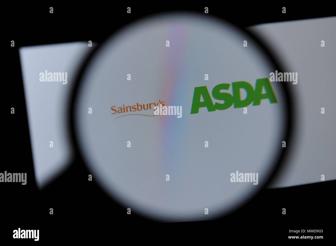 Die Sainsbury's und Asda Logos durch ein Vergrößerungsglas gesehen Stockfoto