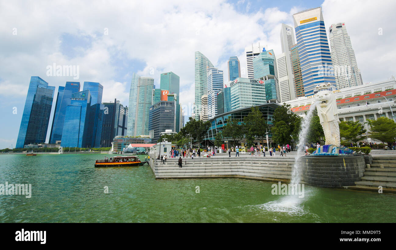 Der Merlion, inoffiziellen Maskottchen von Singapur, halb Fisch, halb Löwe, an der Marina Bay und die Skyline von Singapur im Hintergrund. Stockfoto