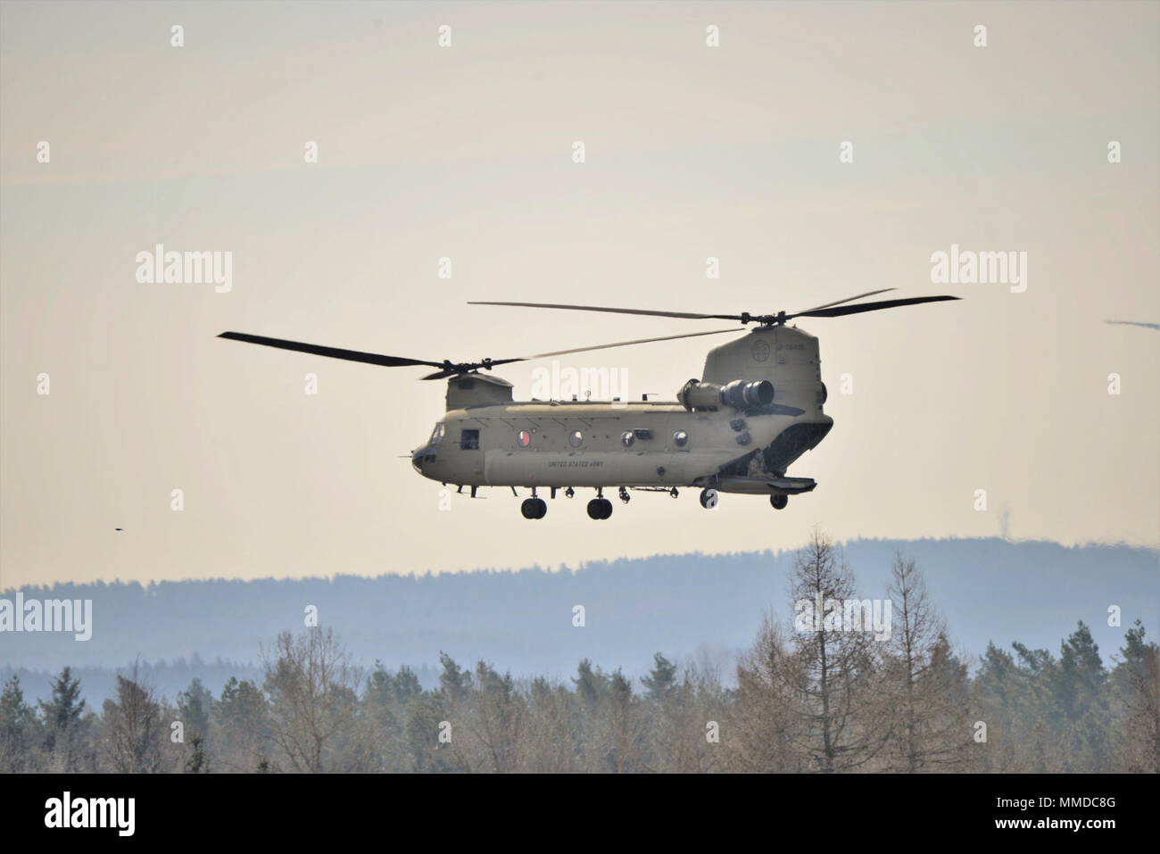 Grafenwöhr, Deutschland - An einem kalten und windigen Nachmittag, eine CH-47 Chinook Hubschrauber auf das erste Bataillon zugeordnet, 3 Aviation Regiment, 12 Combat Aviation Brigade unterstützt Unternehmen, 2.BATAILLON, 503Rd Infanterie Regiment, 173Rd Airborne Brigade während einem Platoon Level Live Fire Übung an der 7th Army Training Befehl Grafenwöhr Training Area, Deutschland, 20. März 2018. (U.S. Armee Stockfoto