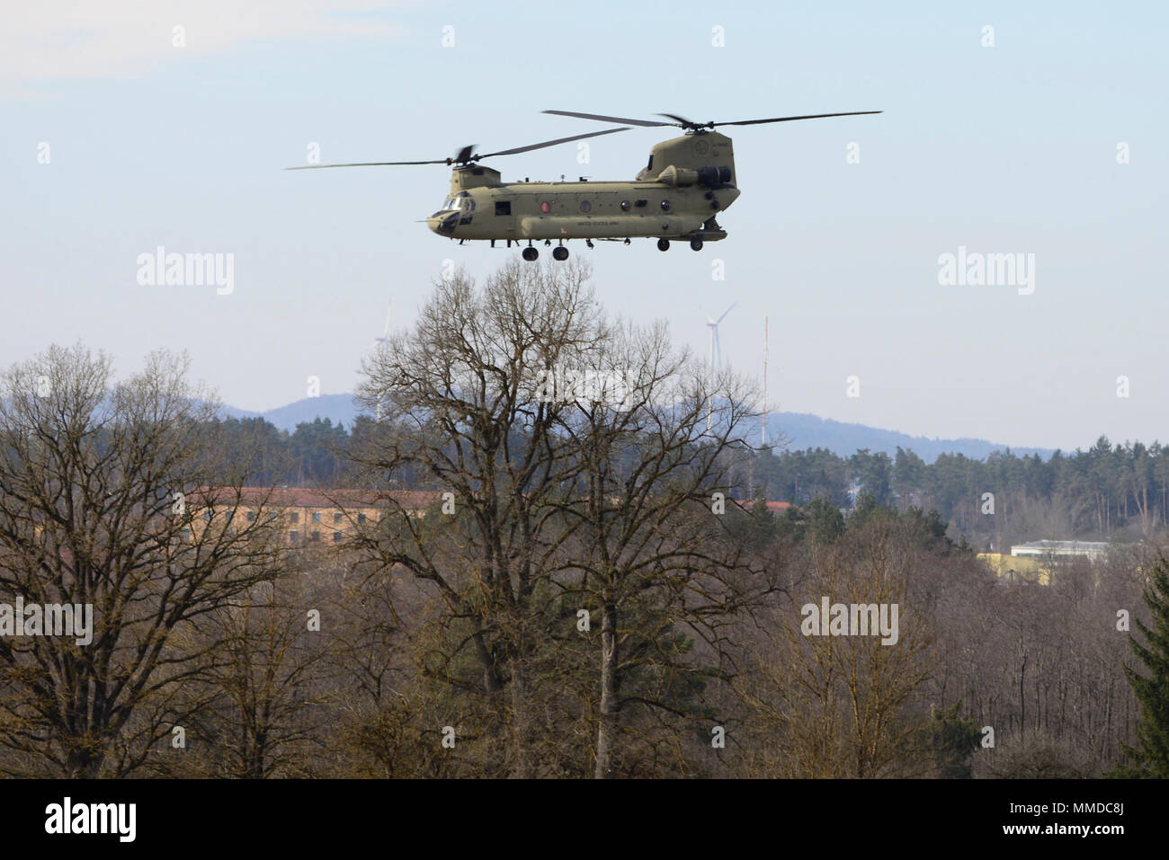 Grafenwöhr, Deutschland - An einem kalten und windigen Nachmittag, eine CH-47 Chinook Hubschrauber auf das erste Bataillon zugeordnet, 3 Aviation Regiment, 12 Combat Aviation Brigade unterstützt Unternehmen, 2.BATAILLON, 503Rd Infanterie Regiment, 173Rd Airborne Brigade während einem Platoon Level Live Fire Übung an der 7th Army Training Befehl Grafenwöhr Training Area, Deutschland, 20. März 2018. (U.S. Armee Stockfoto