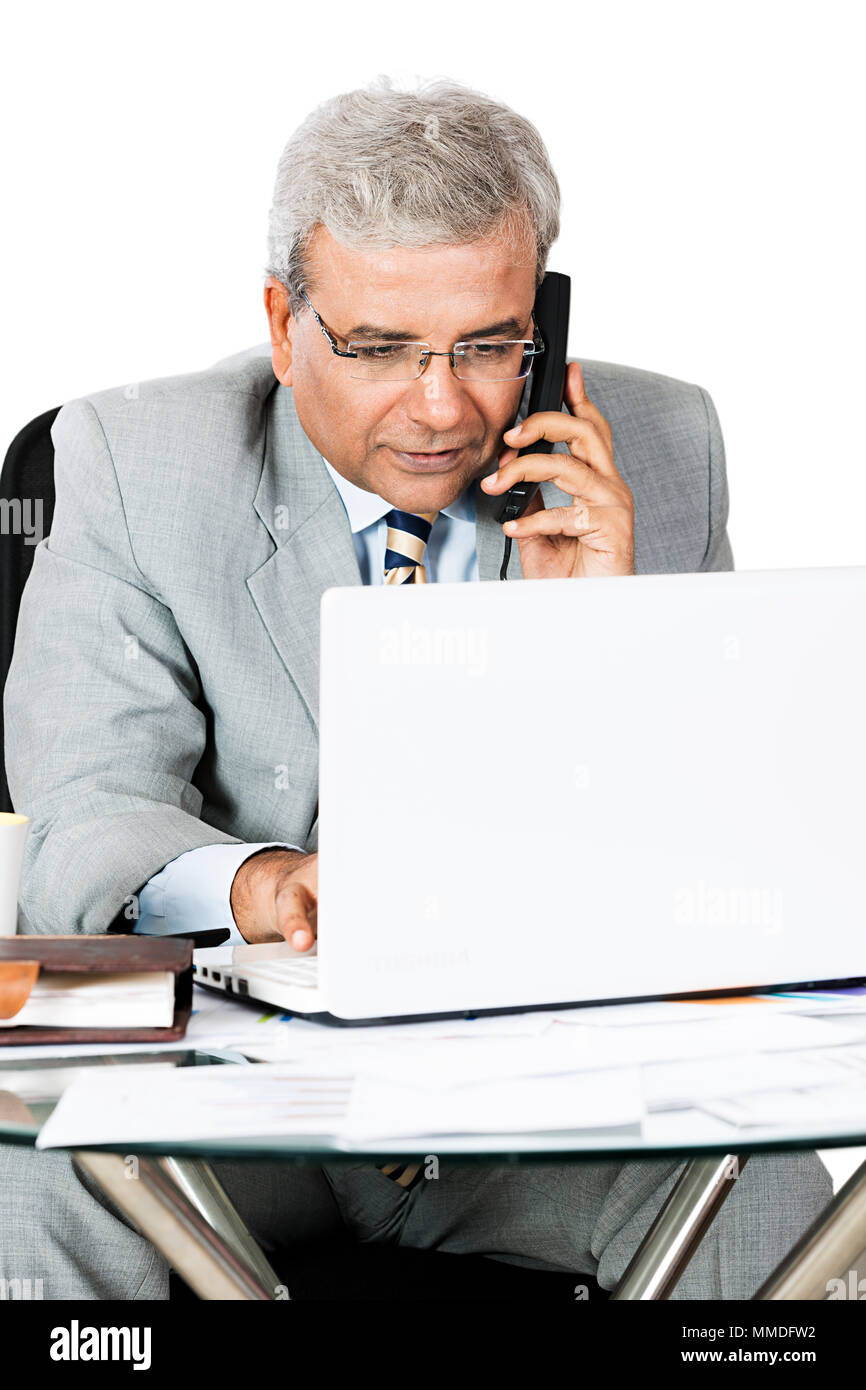 Ein Senior Business Mann mit Laptop und Telefon Multitasking Stockfoto