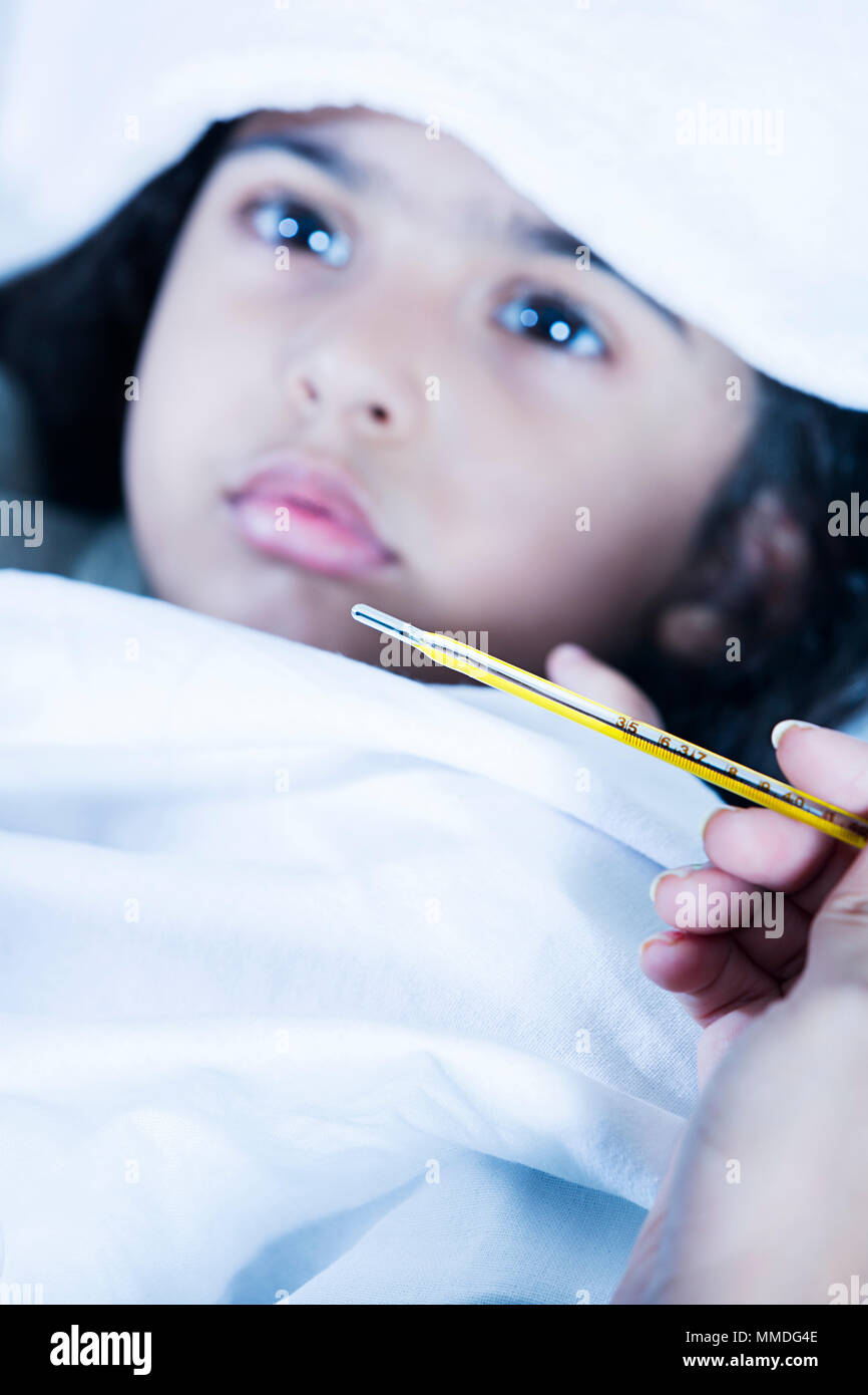 Krankes Kind Mädchen mit hohem Fieber im Bett und Mutter Temperatur prüfen Stockfoto